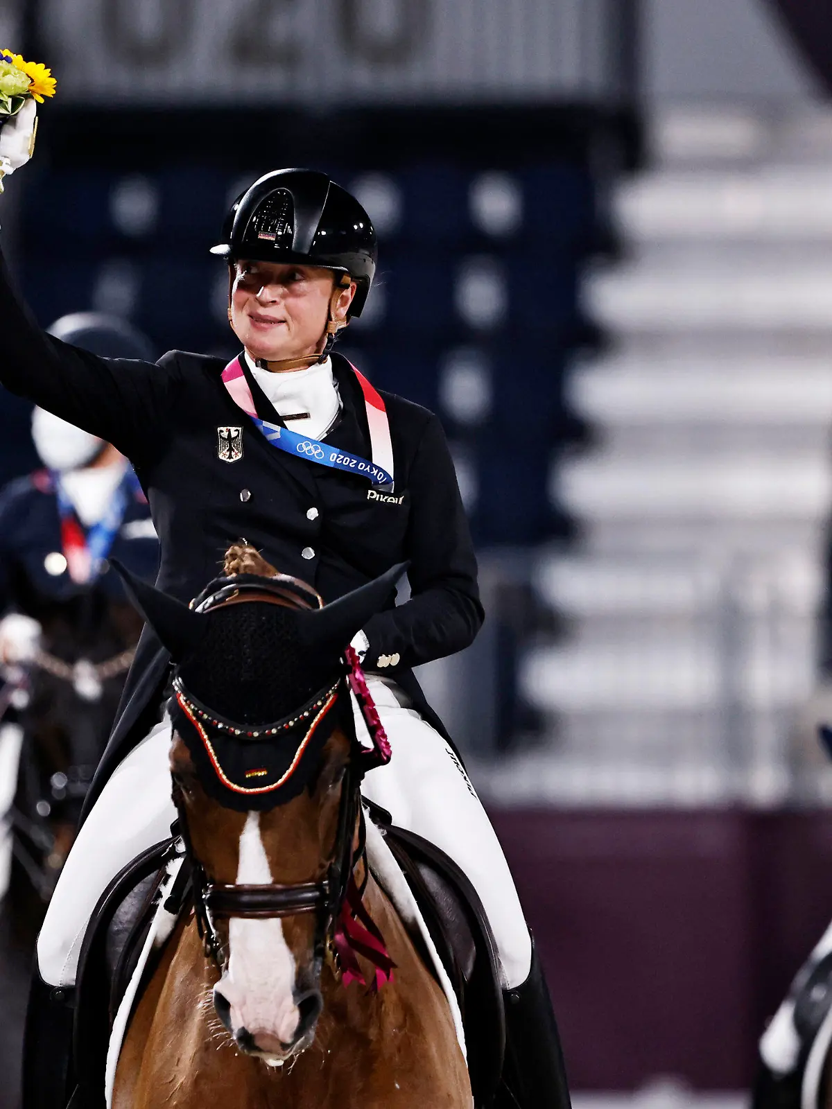 Gold medalist Isabell Werth of Germany rides on her horse together with other medalists after the medal ceremony of the Equestrian Dressage team final at Equestrian Park at Equestrian Park during the 2020 Summer Olympics, Tuesday, July 27, 2021, in Tokyo, Japan. (Alkis Konstantinidis/Pool Photo via AP)
