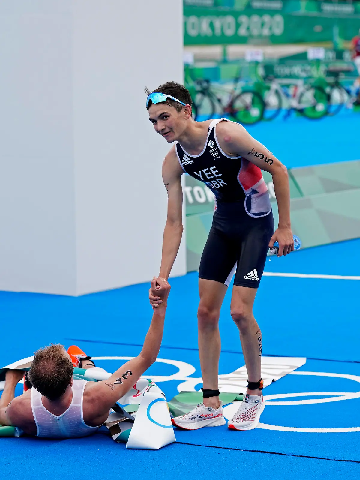 Alex Yee of Great Britain, who won the silver medal helps up Kristian Blummenfelt of Norway who won the gold, during the men's individual triathlon at the 2020 Summer Olympics, Monday, July 26, 2021, in Tokyo, Japan. (AP Photo/Jae C. Hong)