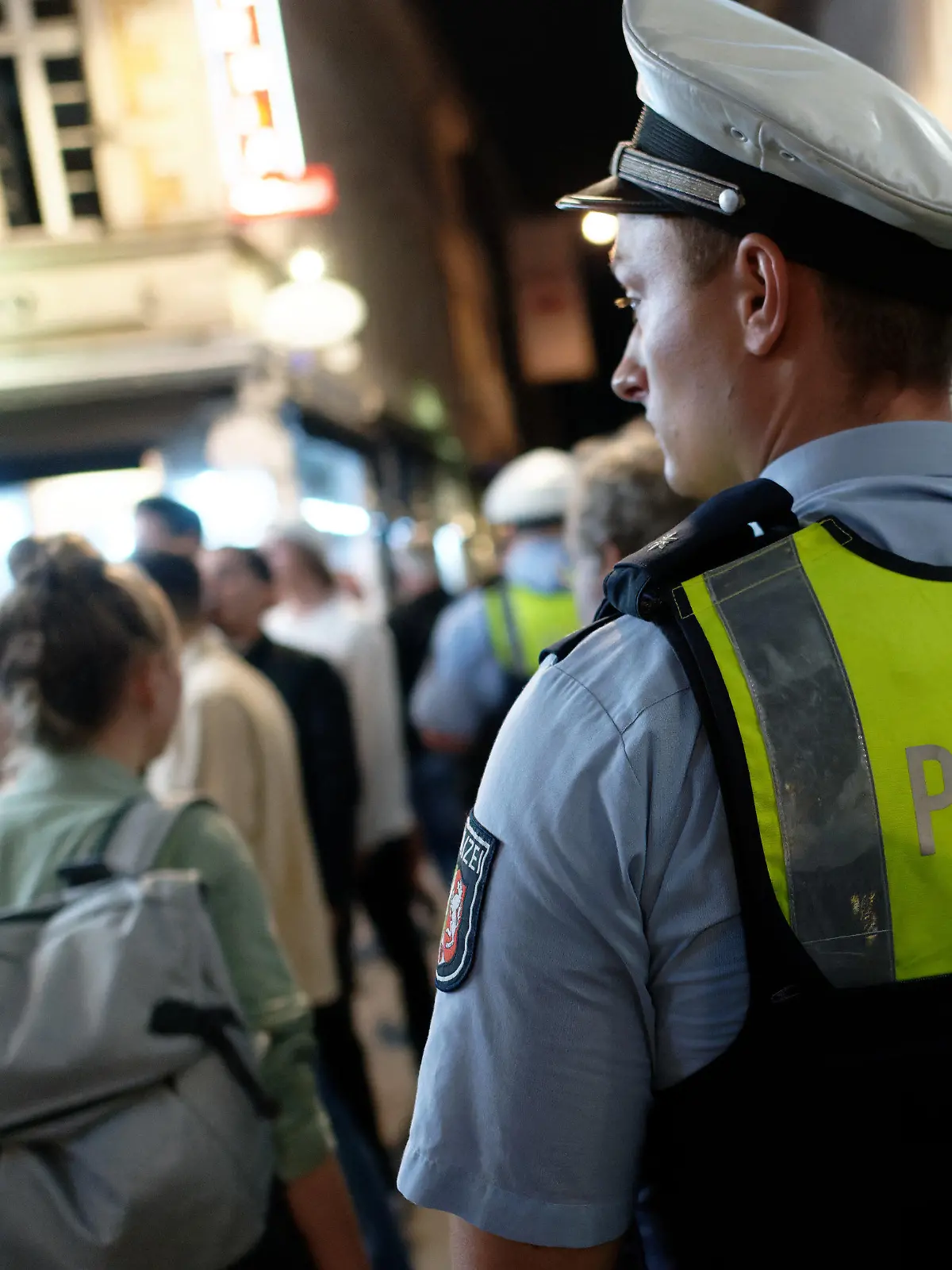 10.07.2021, Nordrhein-Westfalen, Düsseldorf: Polizisten im Dienst patrouillieren nach Mitternacht in der Altstadt zwischen Feiernden. Nach dem Wegfall der meisten Einschränkungen kehrt das Nachtleben in das Vergnügungsviertel zurück. Foto: Henning Kaiser/dpa +++ dpa-Bildfunk +++