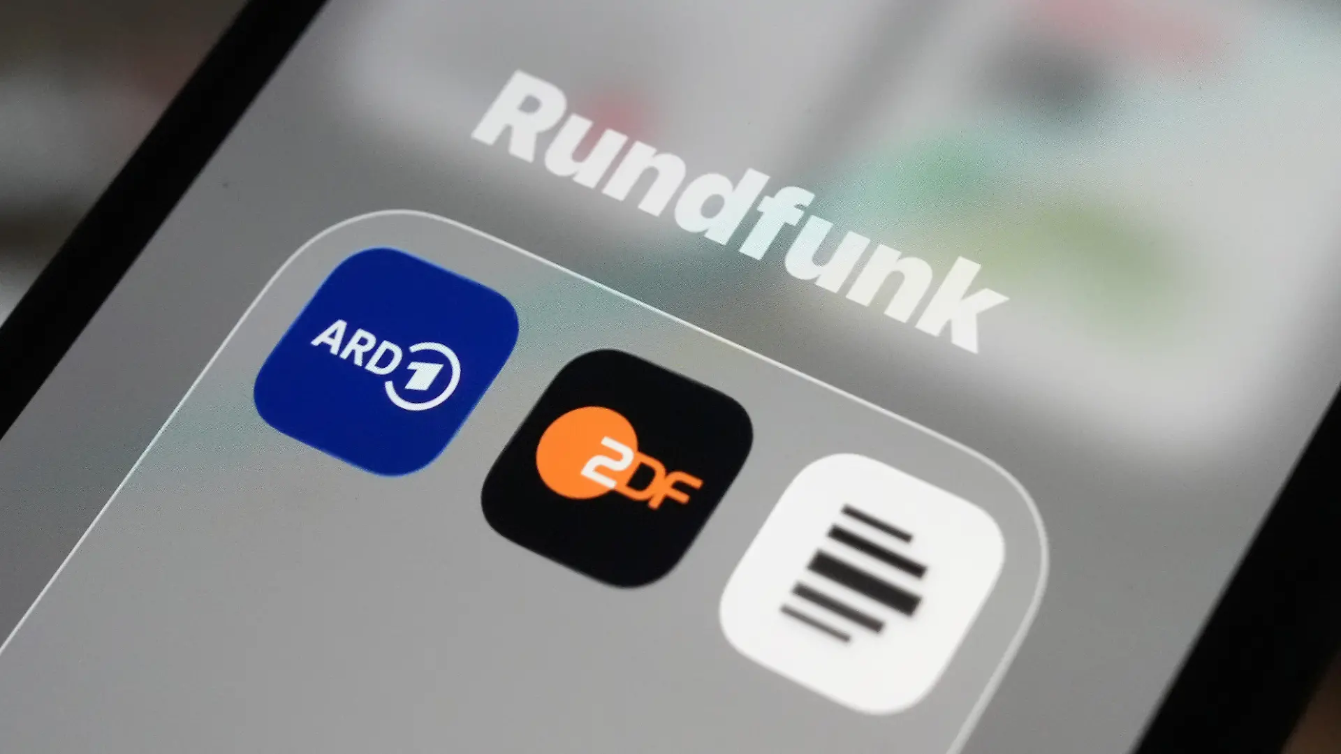 Auf dem Bildschirm eines Smartphones sind die App-Icons von ARD (l-r), ZDF und Deutschlandfunk im Ordner «Rundfunk» zu sehen. Der Reformstaatsvertrag, der am 1. Dezember in Kraft tritt, regelt Aufgaben, Arbeitsweise und digitale Ausrichtung von ARD, ZDF und Deutschlandradio neu.