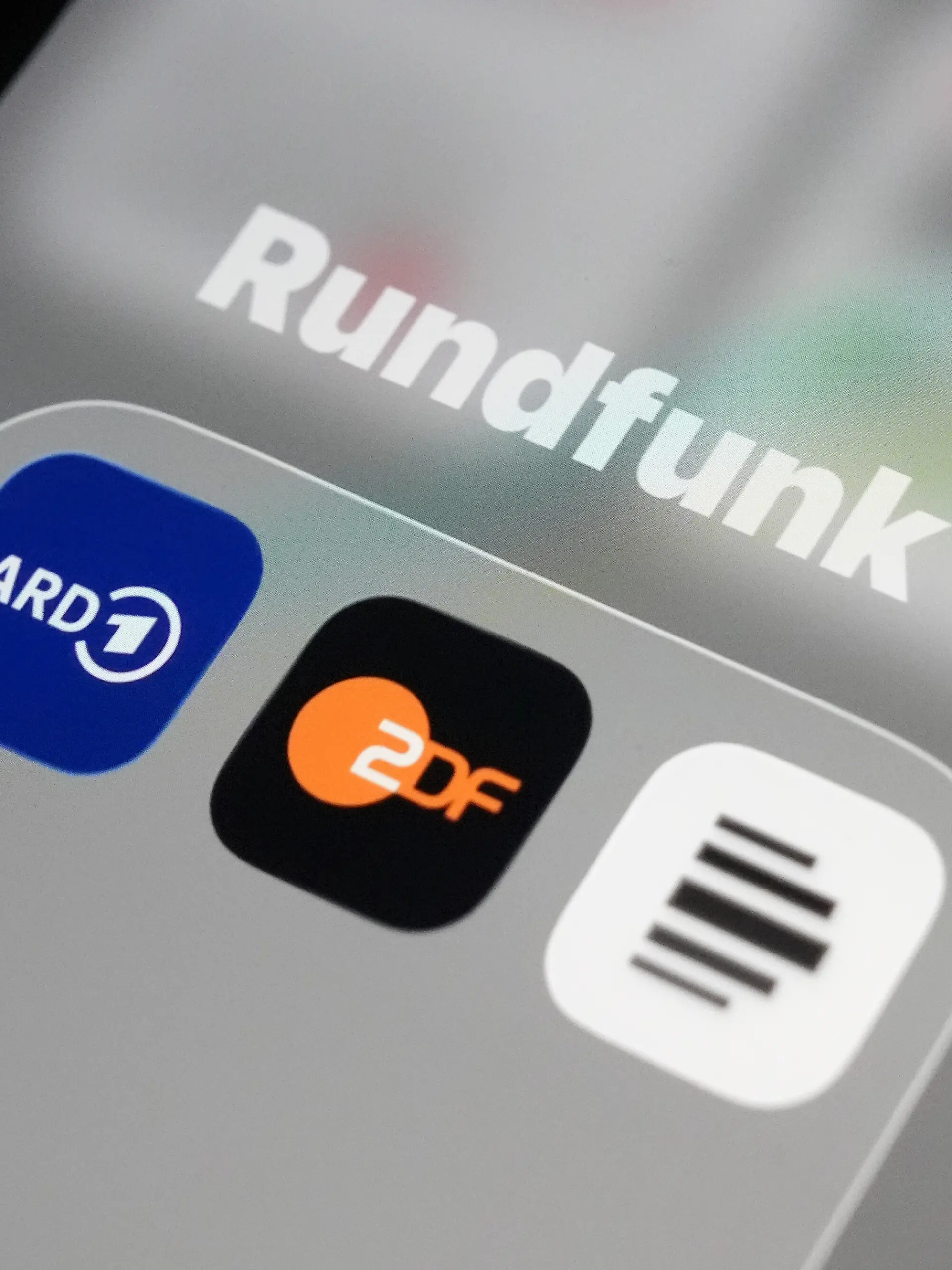 Auf dem Bildschirm eines Smartphones sind die App-Icons von ARD (l-r), ZDF und Deutschlandfunk im Ordner «Rundfunk» zu sehen. Der Reformstaatsvertrag, der am 1. Dezember in Kraft tritt, regelt Aufgaben, Arbeitsweise und digitale Ausrichtung von ARD, ZDF und Deutschlandradio neu.