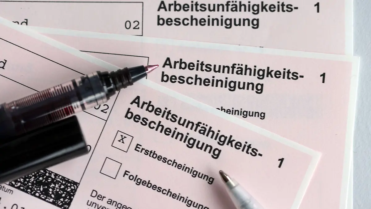 Stifte liegen auf Arbeitsunfähigkeitsbescheinigungen.