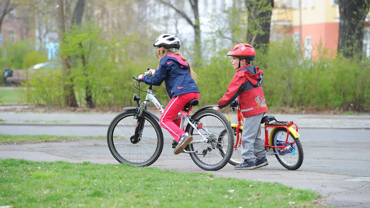 Ein Mädchen und ein Junge beim Fahrradfahren (Symbolbild).