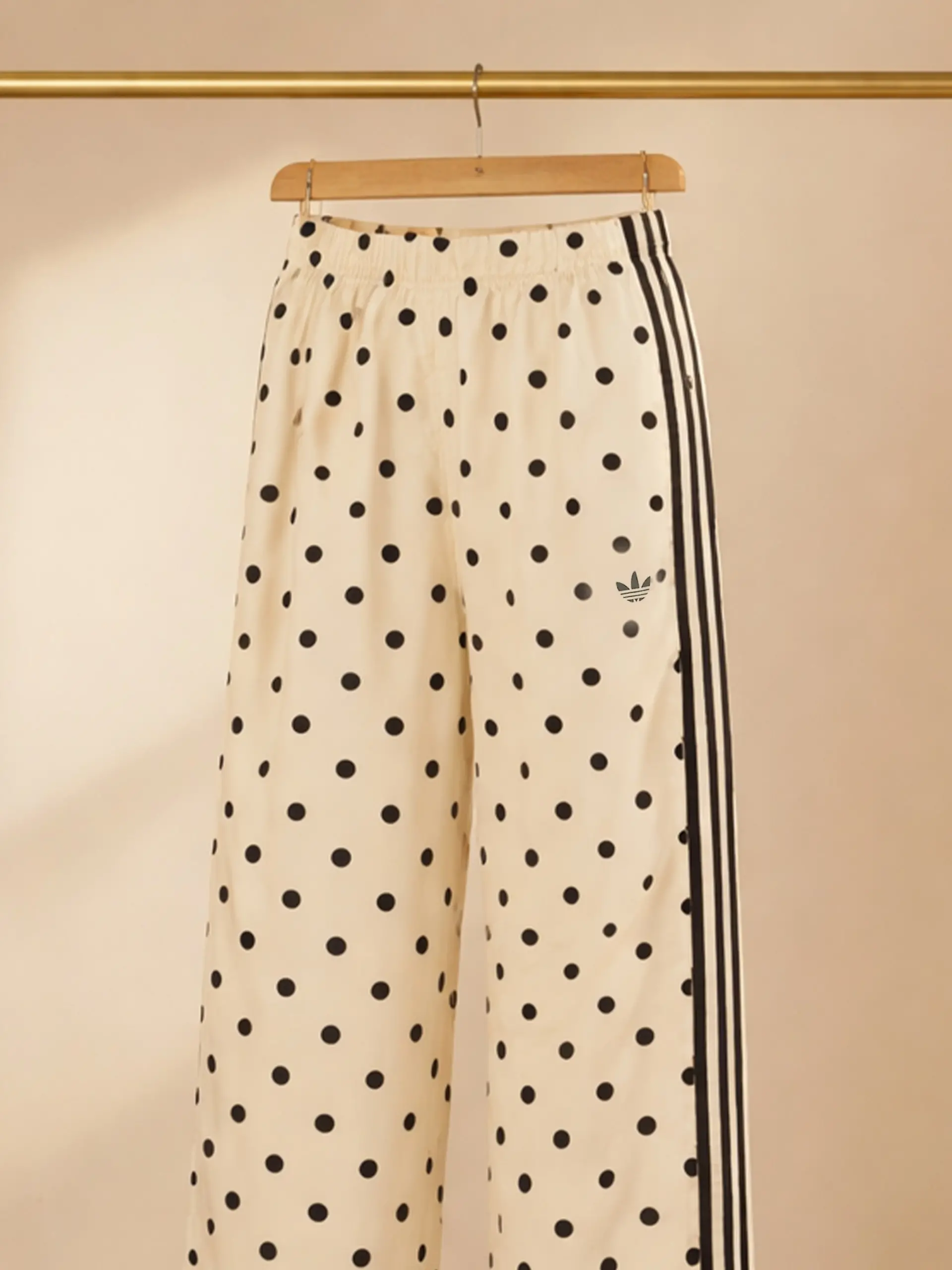 Gepunktete Jogginghose von Adidas auf einer Kleiderstange.