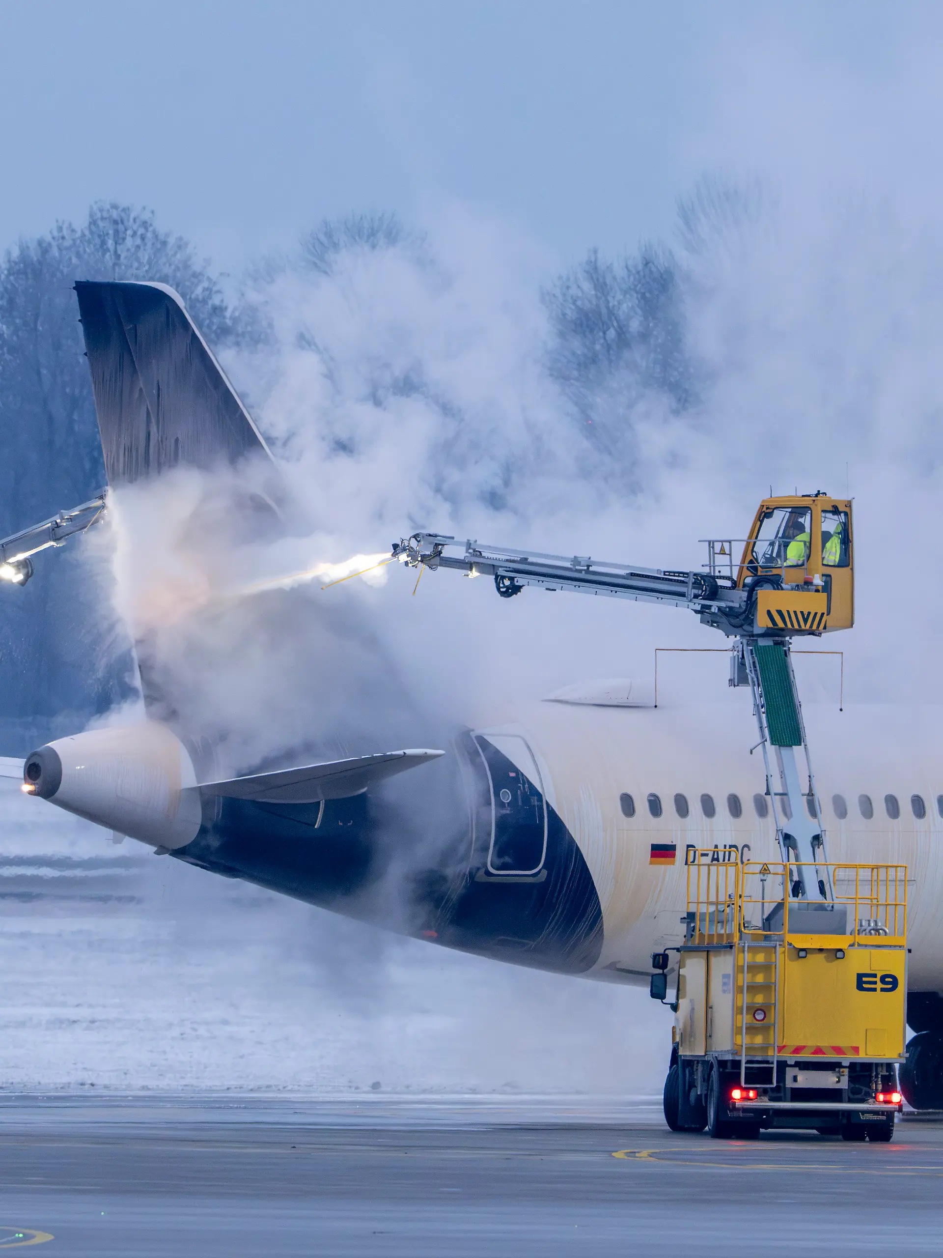Am Flughafen München wird in den frühen Morgenstunden ein Flugzeug der Airline Lufthansa auf einer Enteisungsfläche von Spezialfahrzeugen enteist. +++ dpa-Bildfunk +++