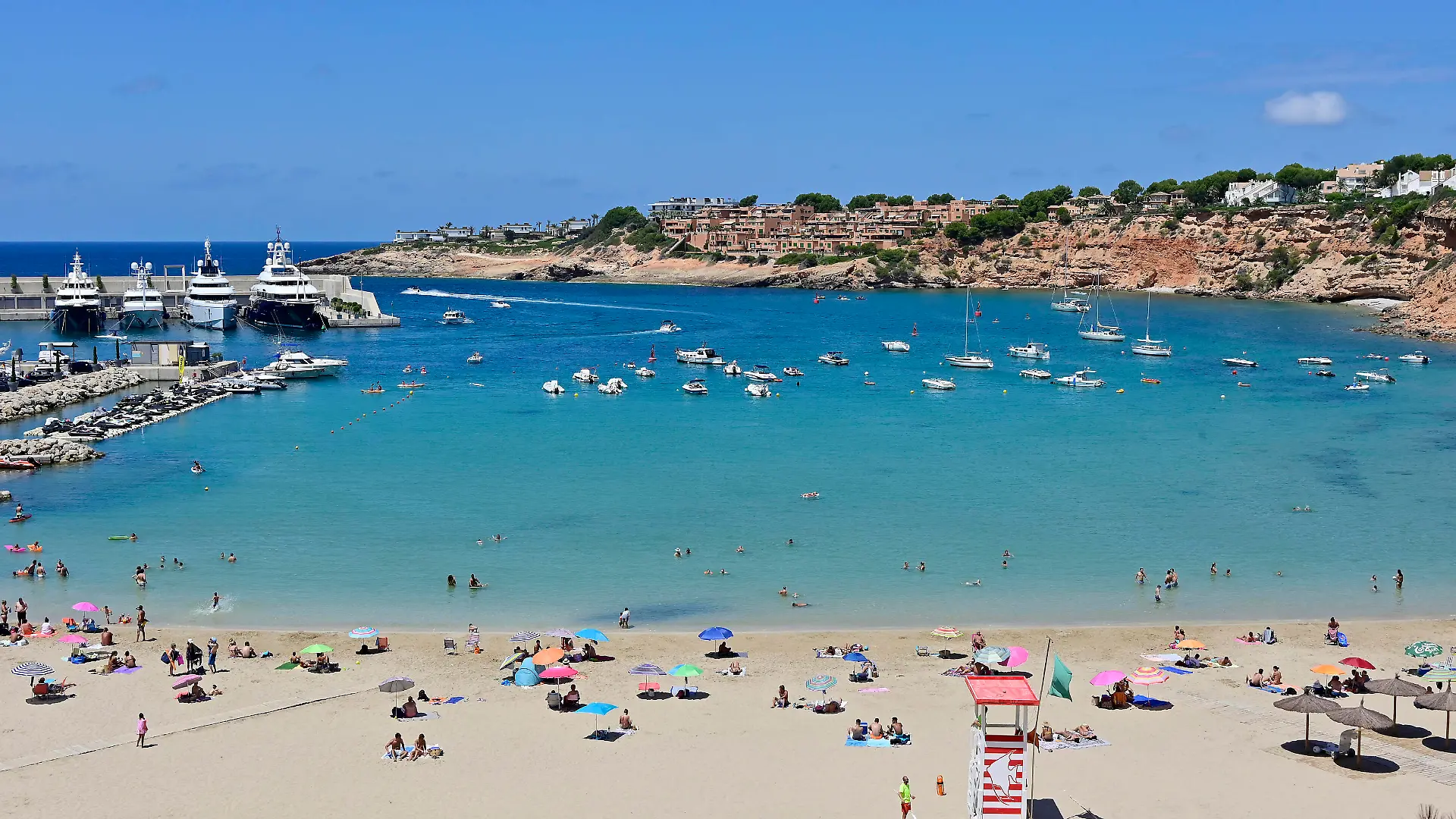 18.07.2020. Spanien, Baleraren, Mallorca. Port Adriano. Der im Jahre 1992 erbaute Yachthafen befindet sich im suedwestlichen Teil der Bucht von Palma de Mallorca und hat sich mittlerweile zu einem der beliebtesten Sporthaefen im Mittelmeerraum etabliert. Von hier werden Ausfluege zu den Nachbarinseln angeboten. Ausserdem gilt er als Ausgangspunkt fuer Ausfluege und Segelturns entlang der mallorquinischen Kueste. Blick auf die Badebucht direkt am Hafen. Mallorcaurlaub waehrend der Coronakrise *** 18 07 2020 Spain, Baleraren, Mallorca Port Adriano The marina was built in 1992 and is located in the south-western part of the bay of Palma de Mallorca. It has become one of the most popular marinas in the Mediterranean area.
