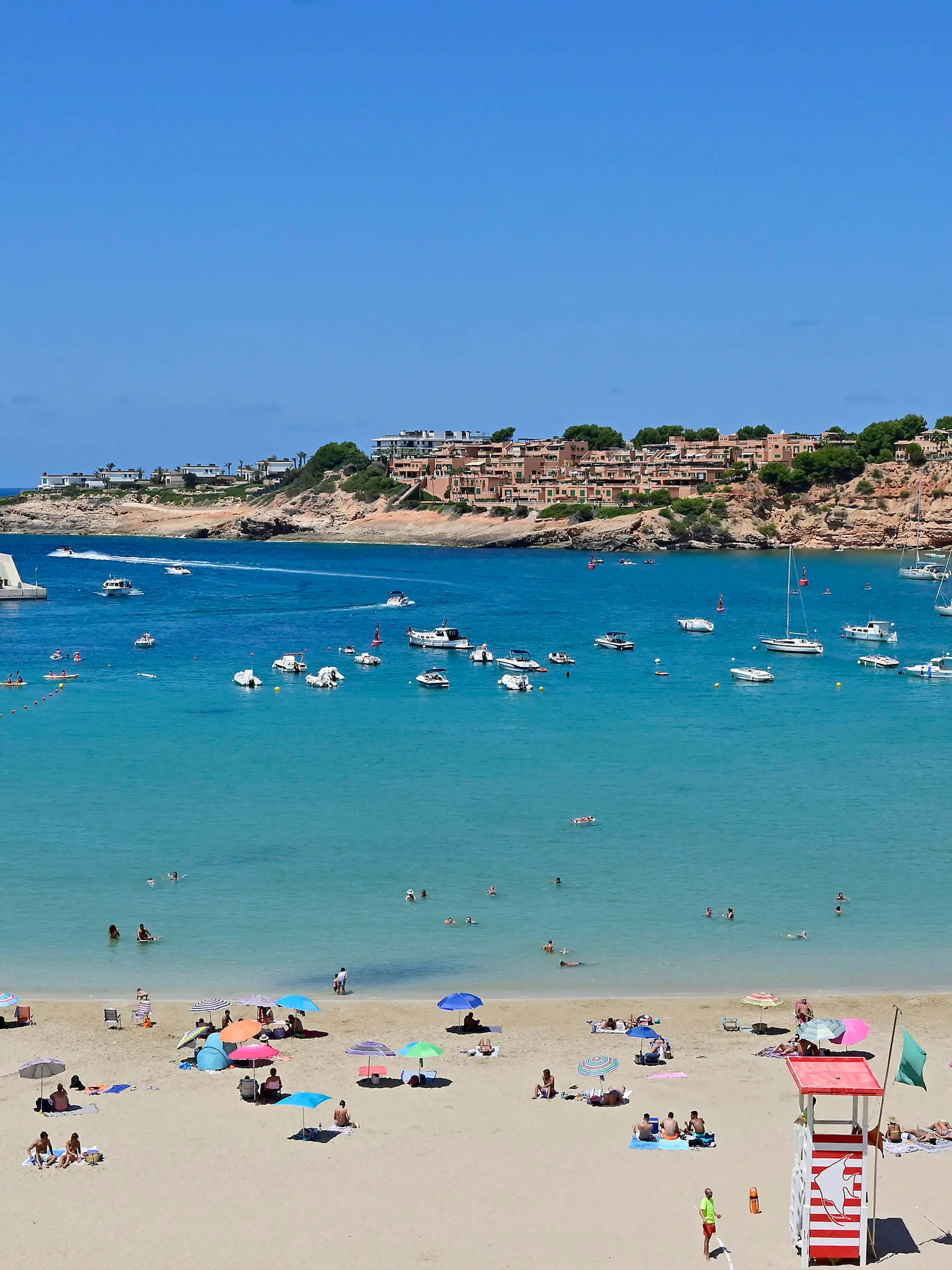  18.07.2020. Spanien, Baleraren, Mallorca. Port Adriano. Der im Jahre 1992 erbaute Yachthafen befindet sich im suedwestlichen Teil der Bucht von Palma de Mallorca und hat sich mittlerweile zu einem der beliebtesten Sporthaefen im Mittelmeerraum etabliert. Von hier werden Ausfluege zu den Nachbarinseln angeboten. Ausserdem gilt er als Ausgangspunkt fuer Ausfluege und Segelturns entlang der mallorquinischen Kueste. Blick auf die Badebucht direkt am Hafen. Mallorcaurlaub waehrend der Coronakrise *** 18 07 2020 Spain, Baleraren, Mallorca Port Adriano The marina was built in 1992 and is located in the south-western part of the bay of Palma de Mallorca. It has become one of the most popular marinas in the Mediterranean area.