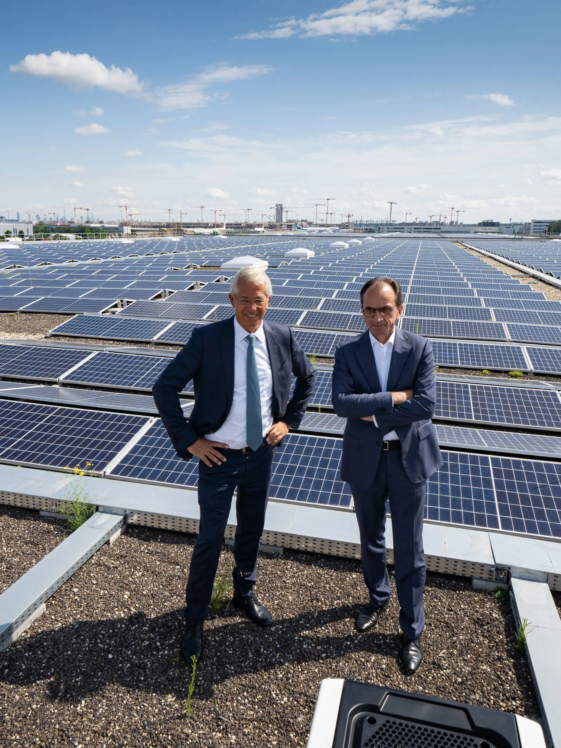 26.07.2021, Hessen, Frankfurt/Main: Stefan Schulte (l), Vorstandsvorsitzender der Fraport AG, und der hessische Finanzminister Michael Boddenberg (CDU) stehen auf dem Dach einer Cargo-Halle vor den Kollektoren für Solarenergie, die 1,6 Megawatt Strom liefern und rund 470 Haushalte damit versorgen könnten. Der Minister als Aufsichtsratsvorsitzender der Fraport AG informierte sich bei seinem Besuch über Klimaschutzmaßnahmen am Frankfurter Flughafen. Foto: Frank Rumpenhorst/dpa +++ dpa-Bildfunk +++