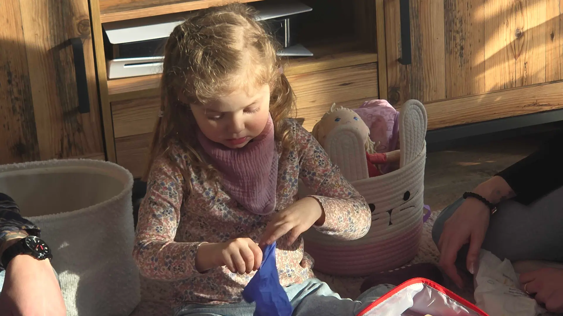 Mara liebt es, mit den blauen Arzthandschuhen zu spielen.