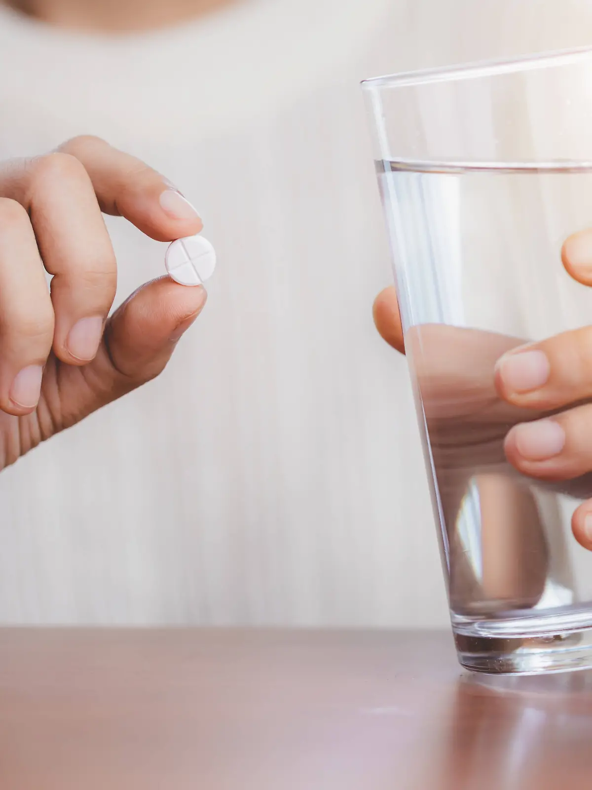 Woman s hand taking medicine pill and drinking water with the brown bottle on the table for healthcare concept. Copyright: x RECORD DATE NOT STATED