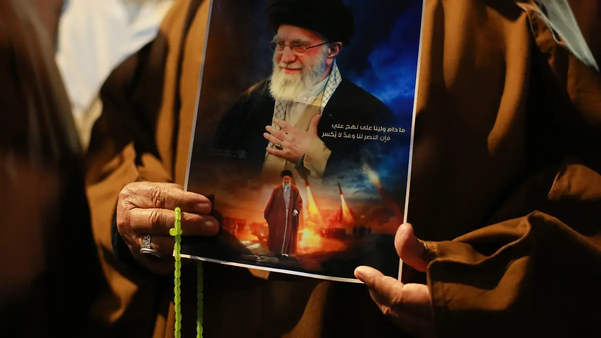 Irakische Schiiten rufen Slogans, tragen ein Porträt von Ajatollah Ali Chamenei und schwenken iranische Flaggen während einer Demonstration in der Nähe der US-Botschaft in Bagdad gegen die jüngsten US-israelischen Angriffe auf den Iran. +++ dpa-Bildfunk +++