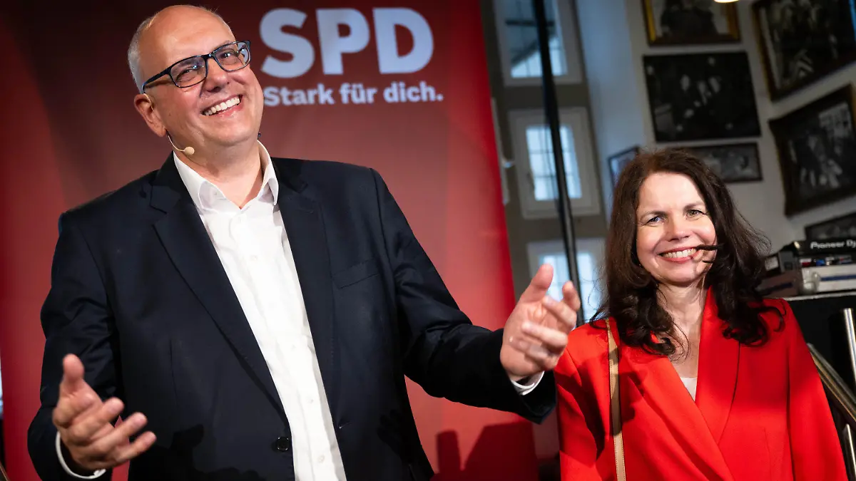 dpatopbilder - 14.05.2023, Bremen: Andreas Bovenschulte, Spitzenkandidat der SPD in Bremen, und seine Partnerin Kerstin Krüger stehen nach Bekanntgabe der ersten Prognose für die Wahl zur Bremischen Bürgerschaft auf der Bühne der SPD-Wahlparty. Im Land Bremen haben am Sonntag die 21. Wahl zur Bremischen Bürgerschaft sowie Kommunalwahlen in Bremen und Bremerhaven stattgefunden Foto: Sina Schuldt/dpa +++ dpa-Bildfunk +++
