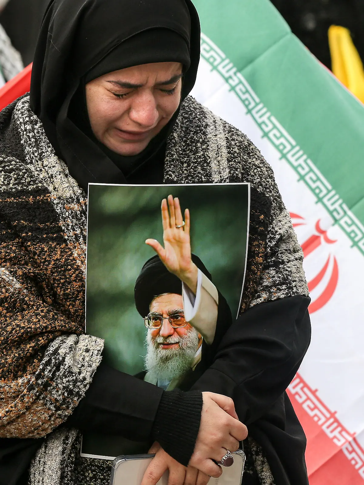 Ein pro-iranischer Hisbollah-Anhänger, der ein Bild des iranischen Obersten Führers Ajatollah Ali Chamenei in der Hand hält, weint während einer Kundgebung. +++ dpa-Bildfunk +++
