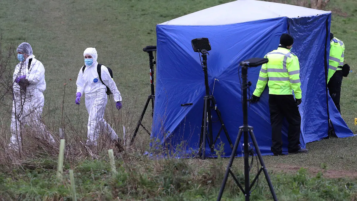 Police forensic officers attend the scene where a 13-year old boy died after being stabbed on Sunday, at the Bugs Bottom field in Reading, England, Monday Jan. 4, 2021.  The police have said five teenagers aged between 13 and 14 are being held in connection with the death. (Jonathan Brady/PA via AP)