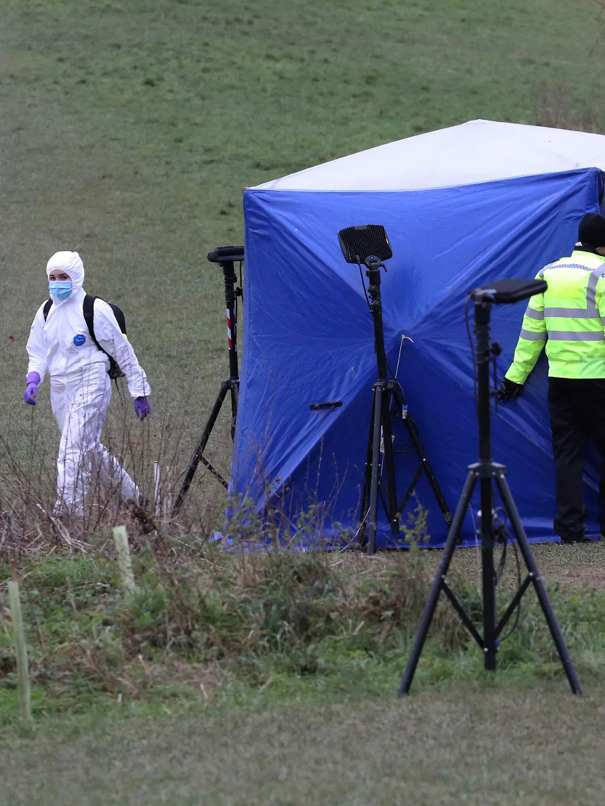 Police forensic officers attend the scene where a 13-year old boy died after being stabbed on Sunday, at the Bugs Bottom field in Reading, England, Monday Jan. 4, 2021.  The police have said five teenagers aged between 13 and 14 are being held in connection with the death. (Jonathan Brady/PA via AP)