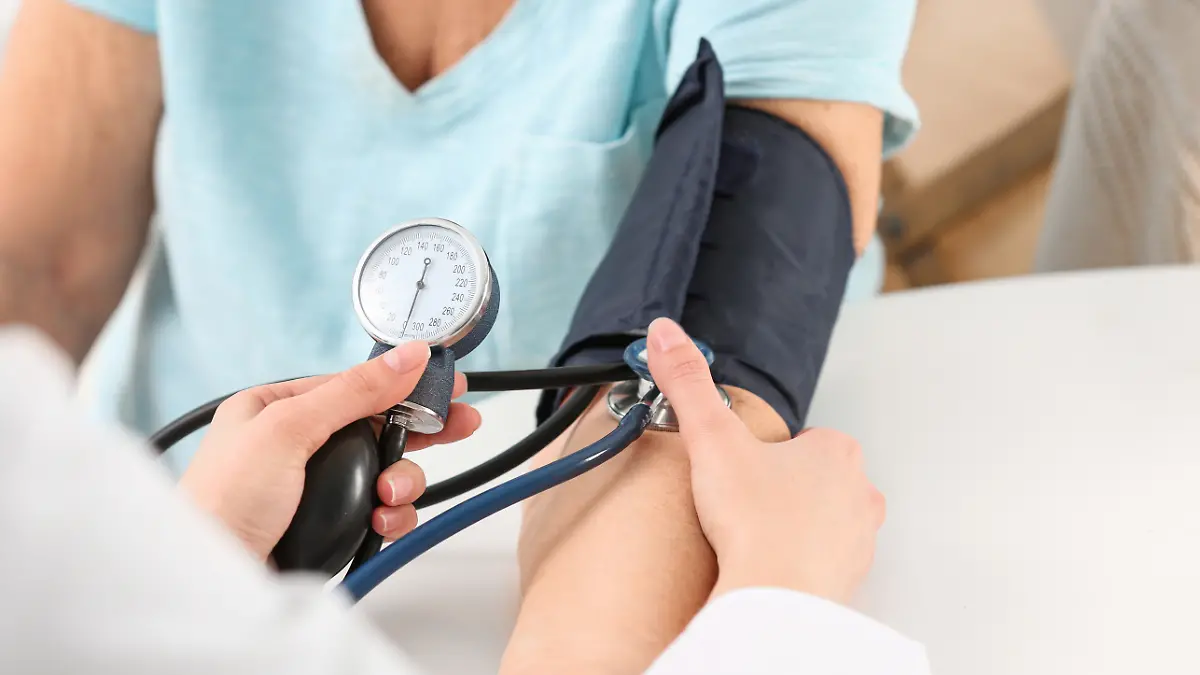 Krankenschwester misst den Blutdruck einer älteren Dame am Tisch, Nahaufnahme. Unterstützung der älteren Generation.