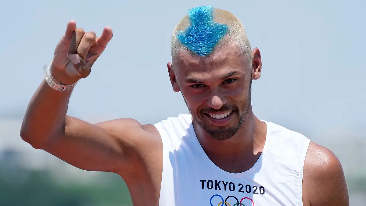 Netherland's Kiran Badloe greets the photographers during a training session of the men's RS:X class at the Enoshima harbor during the 2020 Summer Olympics, Saturday, July 24, 2021, in Fujisawa, Japan. (AP Photo/Gregorio Borgia)