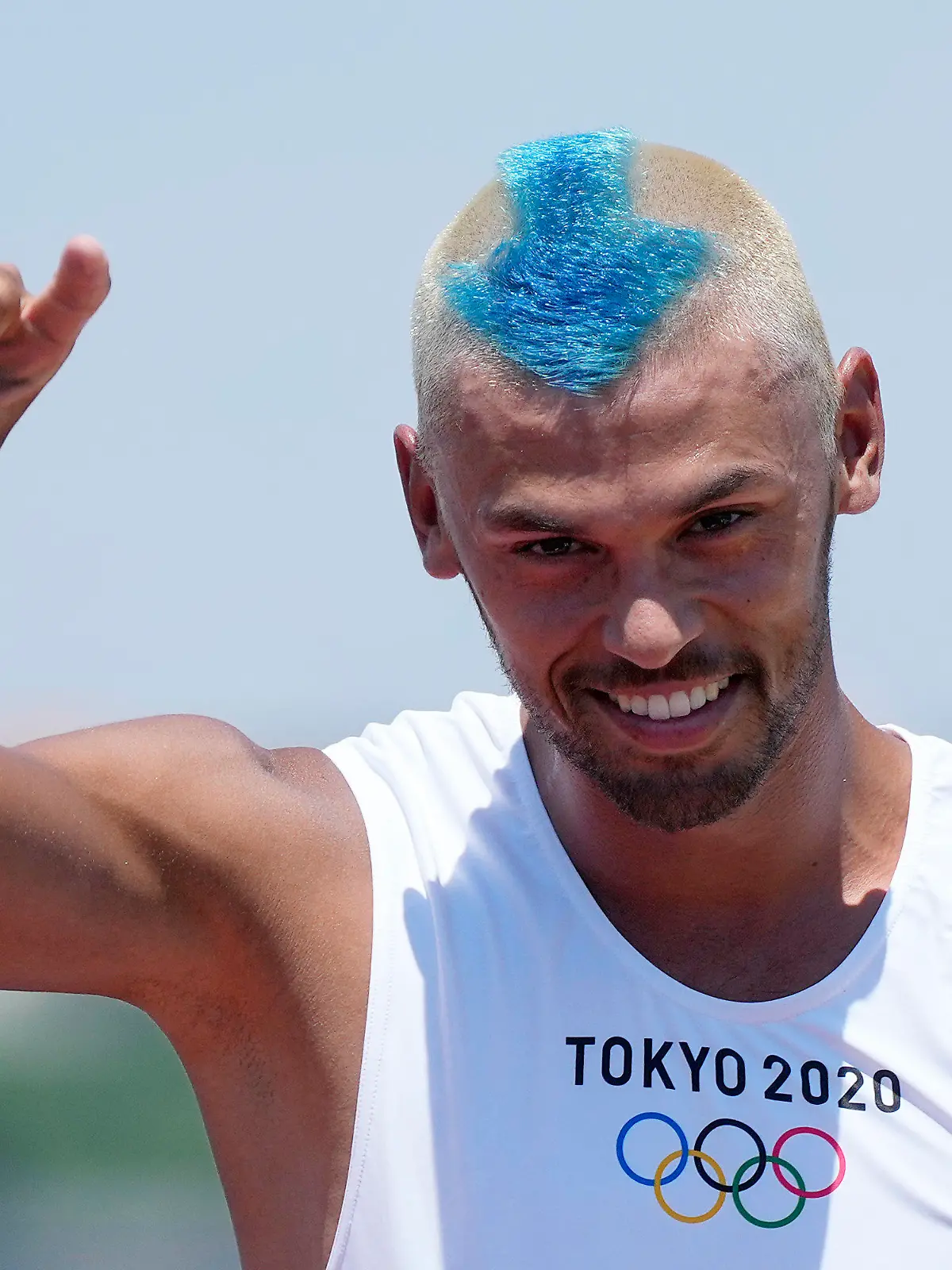 Netherland's Kiran Badloe greets the photographers during a training session of the men's RS:X class at the Enoshima harbor during the 2020 Summer Olympics, Saturday, July 24, 2021, in Fujisawa, Japan. (AP Photo/Gregorio Borgia)