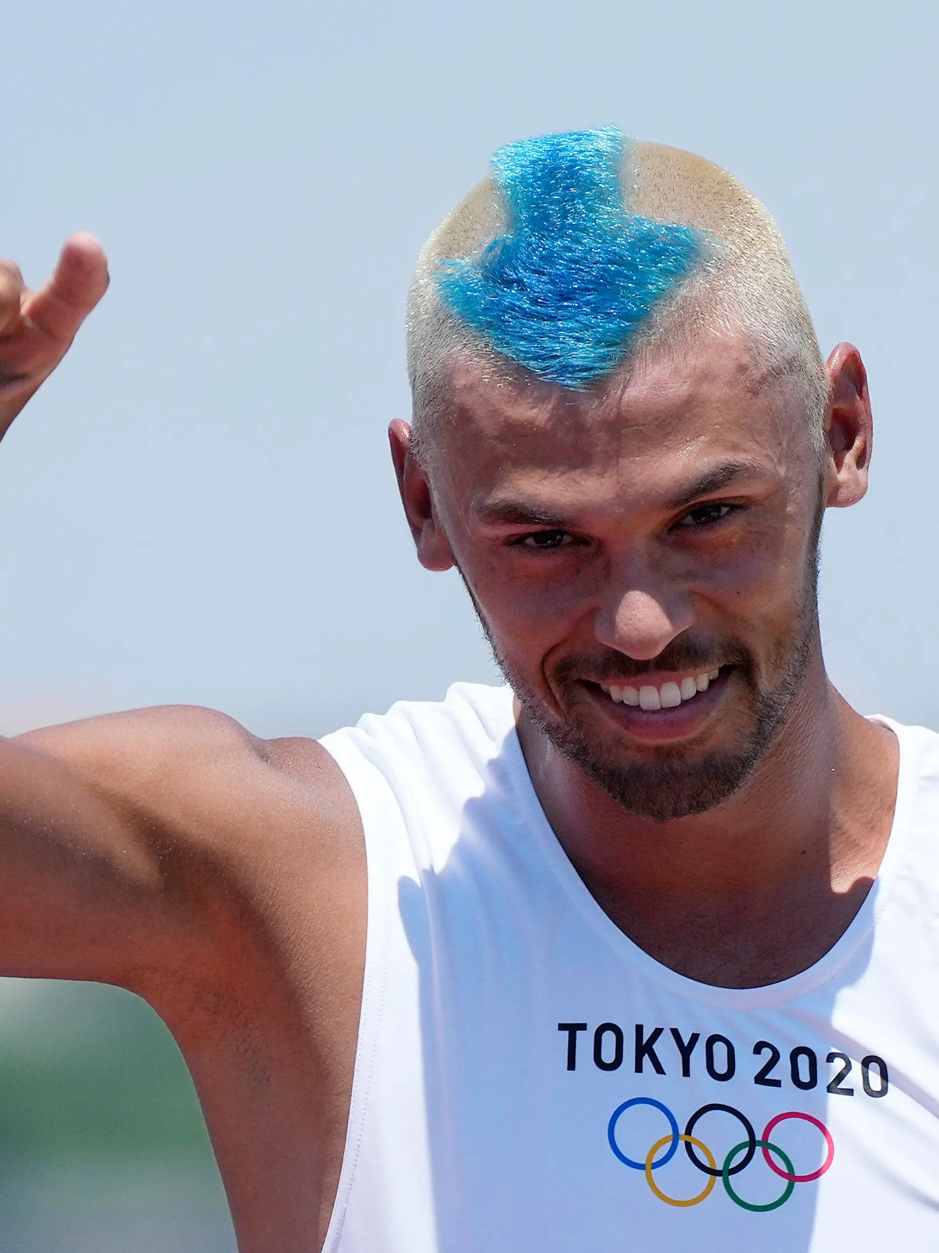 Netherland's Kiran Badloe greets the photographers during a training session of the men's RS:X class at the Enoshima harbor during the 2020 Summer Olympics, Saturday, July 24, 2021, in Fujisawa, Japan. (AP Photo/Gregorio Borgia)