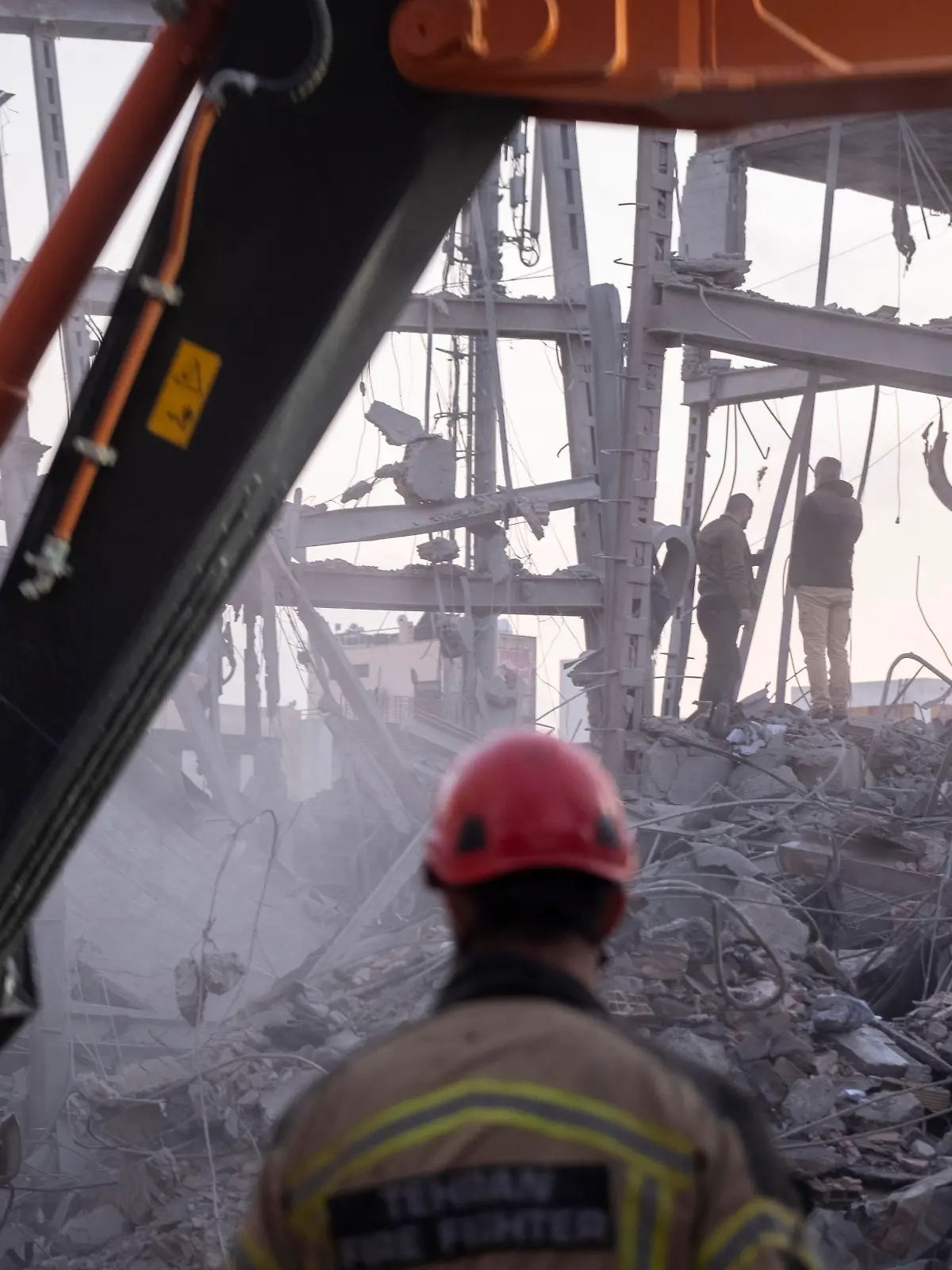 An Iranian firefighter and a loader work on the ruins of a police headquarters that is completely destroyed in U.S.-Israeli attacks in Tehran, Iran, on March 2, 2026. (Photo by Morteza Nikoubazl/NurPhoto)