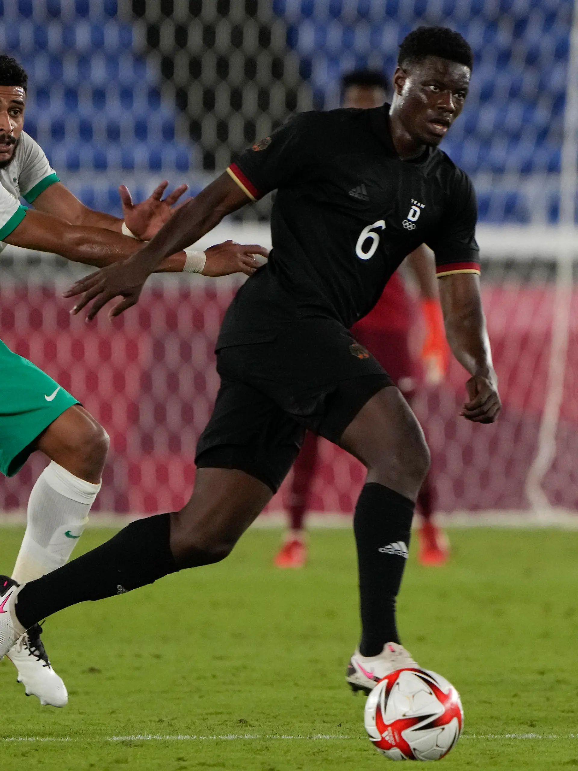 25.07.2021, Japan, Yokohama: Fußball: Olympia, Saudi-Arabien - Deutschland, Vorrunde, Gruppe D, 2. Spieltag im International Stadium Yokohama. Ragnar Ache (r) aus Deutschland erobert den Ball von Abdulelah Alamri aus Saudi-Arabien. Foto: Kiichiro Sato/AP/dpa +++ dpa-Bildfunk +++