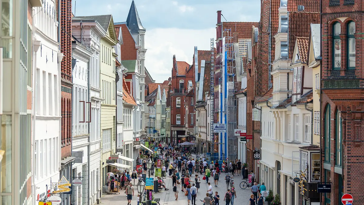 26.07.2021, Niedersachsen, Lüneburg: Menschen gehen durch eine Fußgängerzone in der Innenstadt. Die Corona-Inzidenzen steigen zum Start der Sommerferien weiter: Niedersachsen plant Anpassung der Verordnung. Dass die Werte im Landkreis Lüneburg stark gestiegen sind, hängt wohl vor allem mit einer Abiturfeier in Bardowick zusammen. Foto: Philipp Schulze/dpa +++ dpa-Bildfunk +++