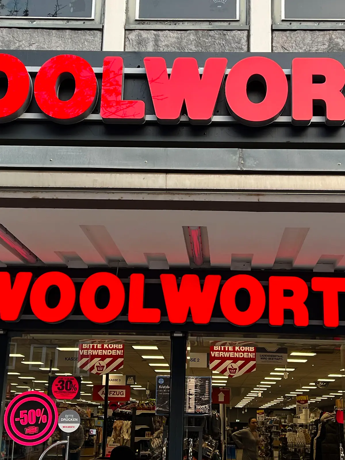 Eingangsbereich mit dem doppelten Woolworht-Schriftzug an der Hauswand einer Filiale in Hamburg im März 2025 - Woolworth Kaufhaus- und Supermarktkette F. W. Woolworth Company