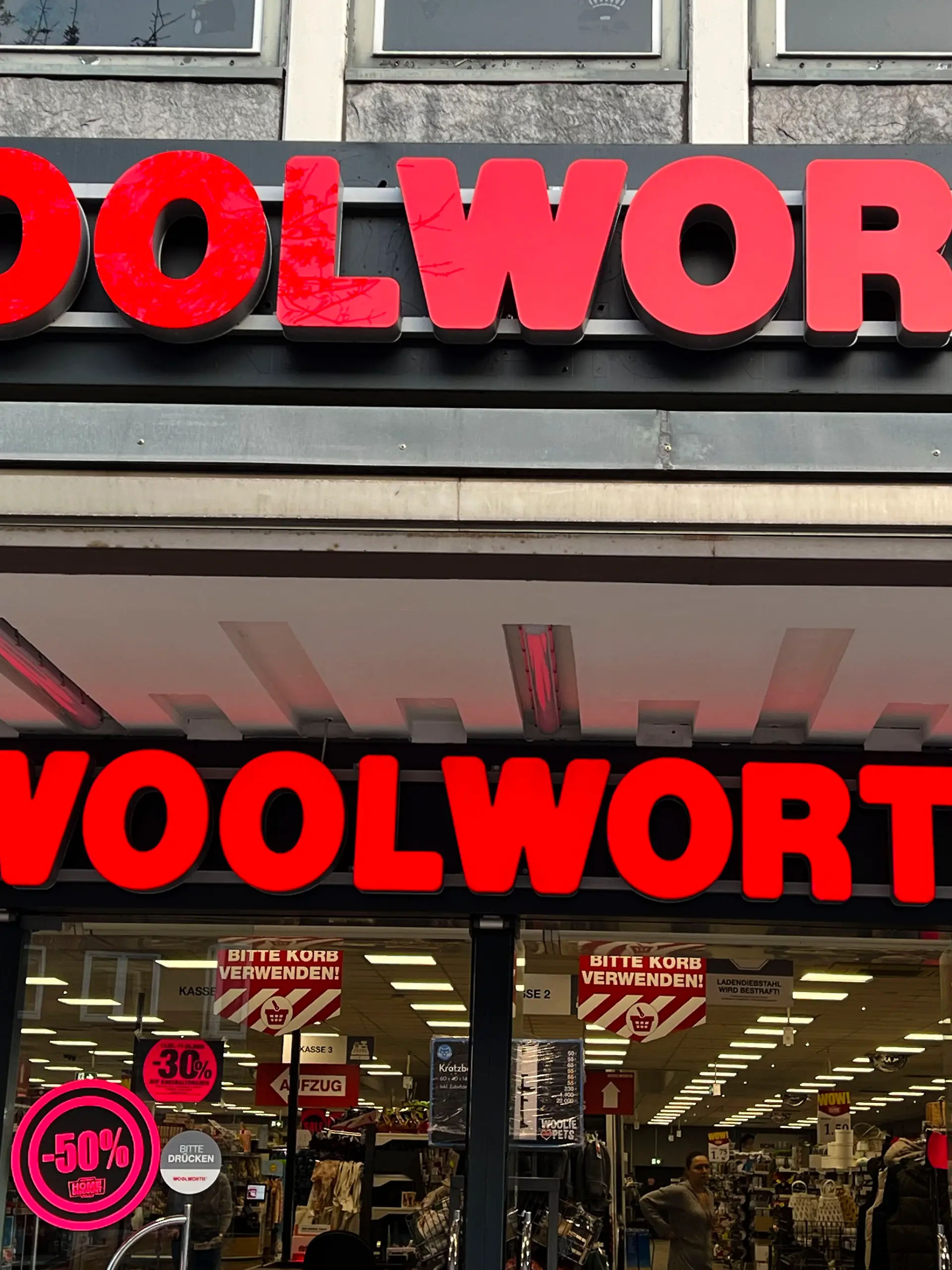 Eingangsbereich mit dem doppelten Woolworht-Schriftzug an der Hauswand einer Filiale in Hamburg im März 2025 - Woolworth Kaufhaus- und Supermarktkette F. W. Woolworth Company