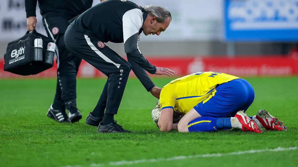 2026.03.04, Fußball, 3.Liga Herren, Rot-Weiss Essen - SV Waldhof Mannheim, Stadion Hafenstraße, 27.Spieltag, Saison 2025 / 2026: Torwart Felix Wienand (Rot-Weiss Essen #35) kniet verletzt auf dem Spielfeld nach dem Zünden von Pyrotechnik im Gästeblock der Mannheimer. Ein Lauter Knall durch einen geworfenen Böller verletzt den Torwart und führt zu einer Spielunterbrechung. Wienand muss medizinisch durch den Arzt versorgt werden DFB regulations prohibit any use of photographs as image sequences and or quasi-video.