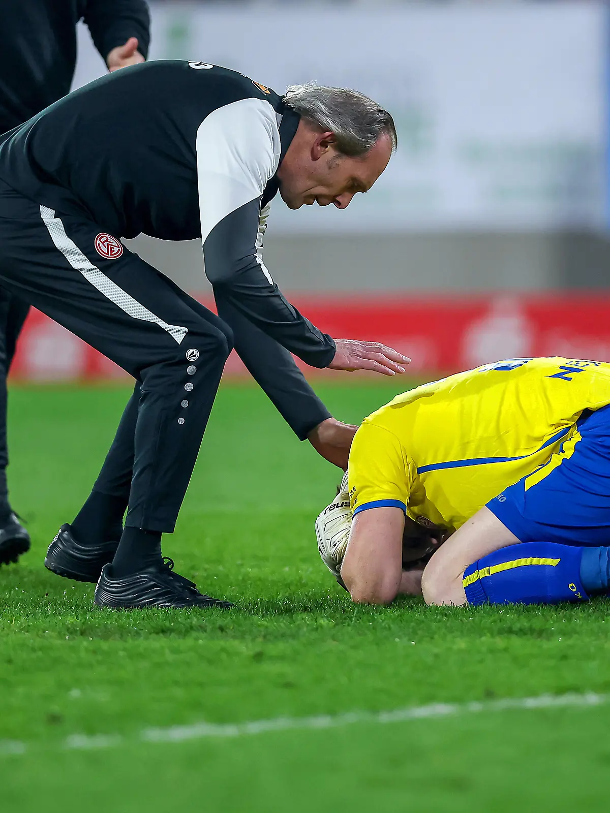 2026.03.04, Fußball, 3.Liga Herren, Rot-Weiss Essen - SV Waldhof Mannheim, Stadion Hafenstraße, 27.Spieltag, Saison 2025 / 2026: Torwart Felix Wienand (Rot-Weiss Essen #35) kniet verletzt auf dem Spielfeld nach dem Zünden von Pyrotechnik im Gästeblock der Mannheimer. Ein Lauter Knall durch einen geworfenen Böller verletzt den Torwart und führt zu einer Spielunterbrechung. Wienand muss medizinisch durch den Arzt versorgt werden DFB regulations prohibit any use of photographs as image sequences and or quasi-video.