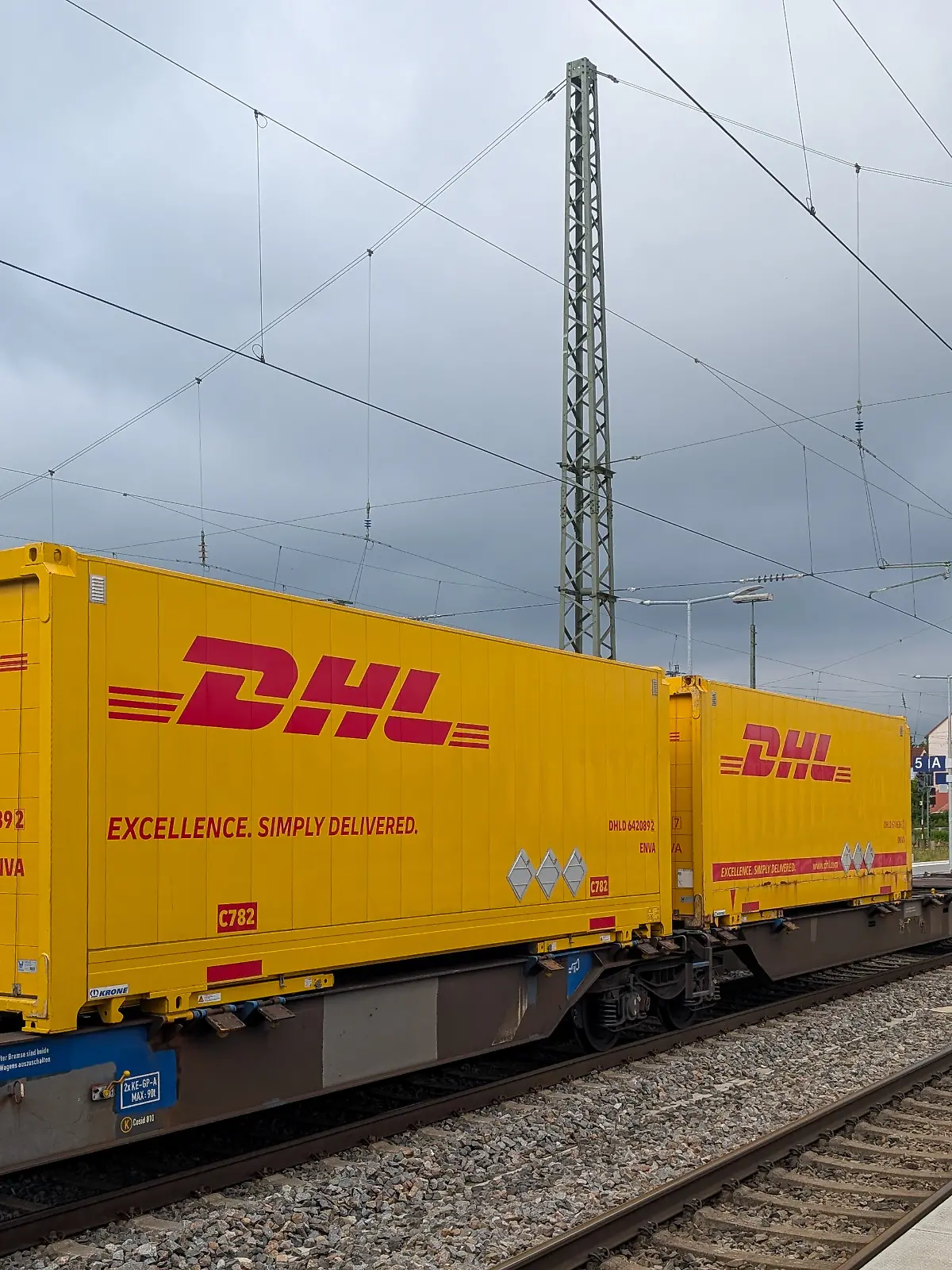 DHL intermodal freight containers are transported on a Deutsche Bahn freight train at the Ansbach train station in Ansbach, Bavaria, Middle Franconia, Germany, on July 26, 2025. The containers bear DHL branding and the slogan ''Excellence. Simply Delivered.'' as part of a rail cargo logistics operation. (Photo by Michael Nguyen/NurPhoto)