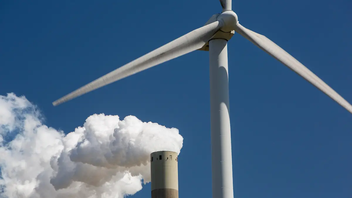 Climate change heaven and hell of a wind turbine with emissions from a coal fired power station in Amsterdam, Netherlands.
