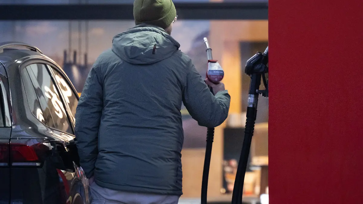 Ein Mann hält an einer Tankstelle eine Zapfpistole. (zu dpa: «Erdölverband: Höhere Einkaufskosten treiben Spritpreise») +++ dpa-Bildfunk +++