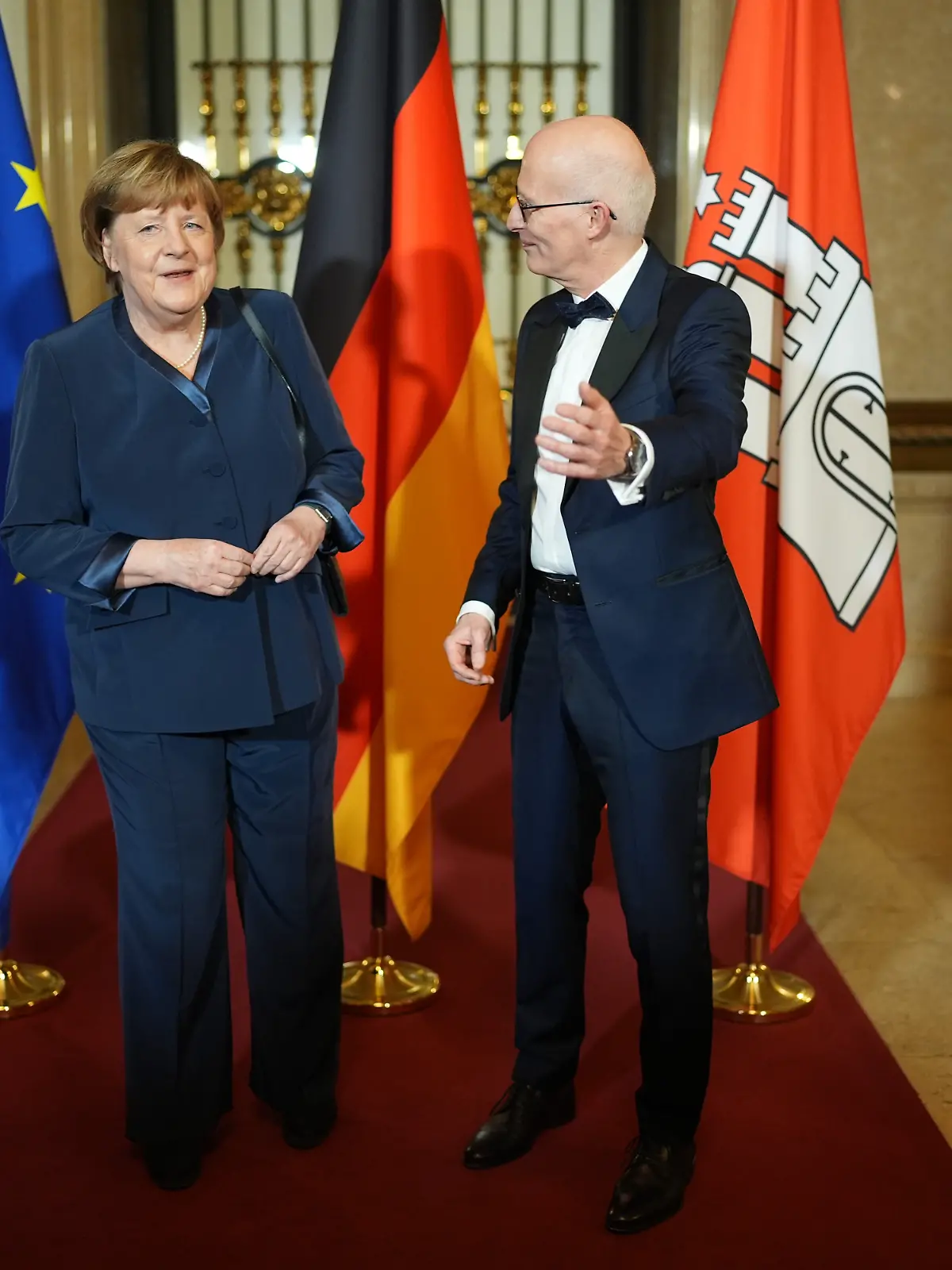 Peter Tschentscher (r, SPD), Erster Bürgermeister und Präsident des Senats der Freien und Hansestadt Hamburg, begrüßt Alt-Bundeskanzlerin Angela Merkel (CDU) auf dem Spiegel im Rathaus beim traditionellen Matthiae-Mahl des Hamburger Senats. Das Matthiae-Mahl gilt als das älteste noch gefeierte Gastmahl der Welt. Die Regierenden der Hansestadt laden dazu seit 1356 ins Rathaus ein.