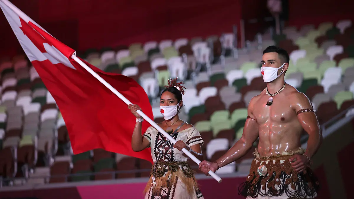 Malia Paseka and Pita Taufatofua, of Tonga, carry their country's flag during the opening ceremony in the Olympic Stadium at the 2020 Summer Olympics, Friday, July 23, 2021, in Tokyo, Japan. (Hannah McKay/Pool Photo via AP)