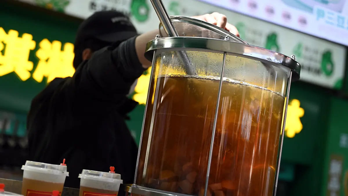 PRODUKTION - 17.02.2026, China, Peking: In einem gläsernen Topf mit warmem Schneebirnen-Saft schwimmen Fruchtstücke und chinesische Datteln. Auf sozialen Medien macht ein Trend die Runde, sich besonders chinesisch zu verhalten und Gebräuche nachzuahmen. (zu dpa: «Warme Füße und Reisbrei: Warum China plötzlich Trend ist») Foto: Johannes Neudecker/dpa +++ dpa-Bildfunk +++