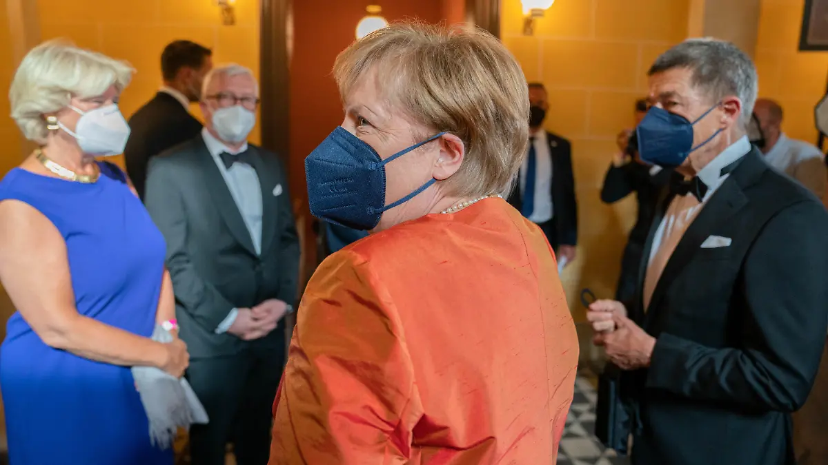 25.07.2021, Bayern, Bayreuth: Eröffnung der Richard-Wagner-Festspiele 2021 mit einer Neuinszenierung der Oper «Der fliegende Holländer». Bundeskanzlerin Angela Merkel (CDU, M) und ihr Mann Joachim Sauer treffen zu den Bayreuther Festspielen im Festspielhaus auf dem Grünen Hügel ein. Links steht Monika Grütters (CDU), Beauftragte der Bundesregierung für Kultur und Medien. Foto: Nicolas Armer/dpa +++ dpa-Bildfunk +++