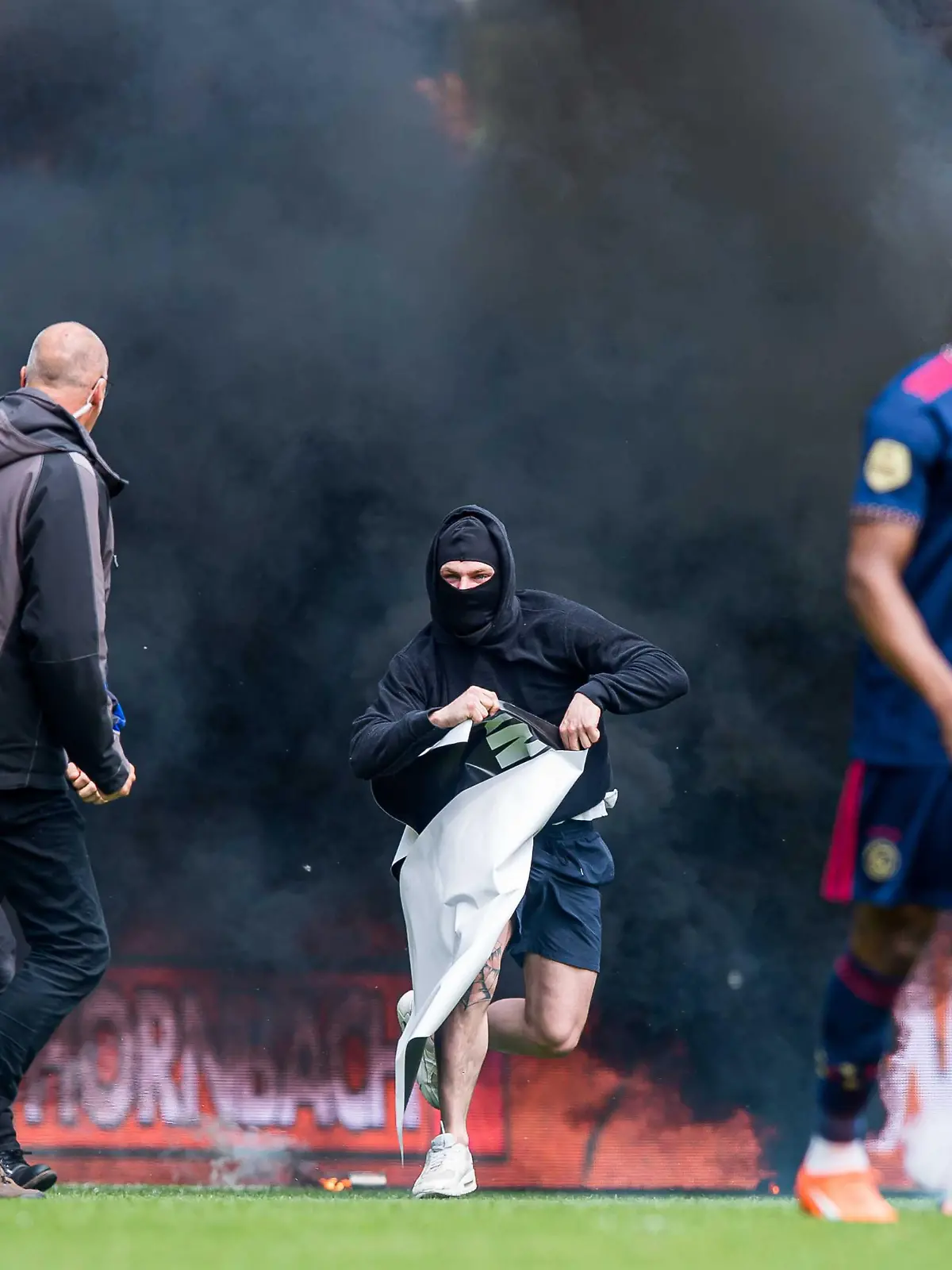 2023-05-14 14:42:42 GRONINGEN  Ein Fan des FC Groningen stürmt mit einem Banner (r) Mohammed Kudus von Ajax das Spielfeld während des niederländischen Premier-League-Spiels zwischen dem FC Groningen und Ajax im Euroborg-Stadion am 14. Mai 2023 in Groningen, Niederlande. ANP COR LASKER