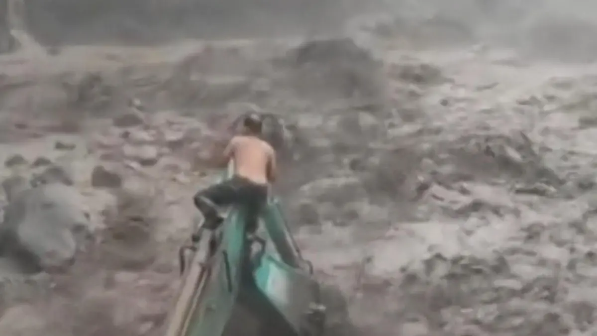 Schlammmassen ausgeliefert! Mann klammert sich verzweifelt an Bagger fest