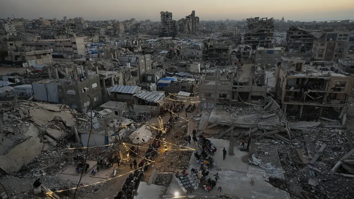 Palästinenser versammeln sich zum Iftar, dem Fastenbrechen, während des muslimischen heiligen Monats Ramadan inmitten der Trümmer zerstörter Gebäude. +++ dpa-Bildfunk +++