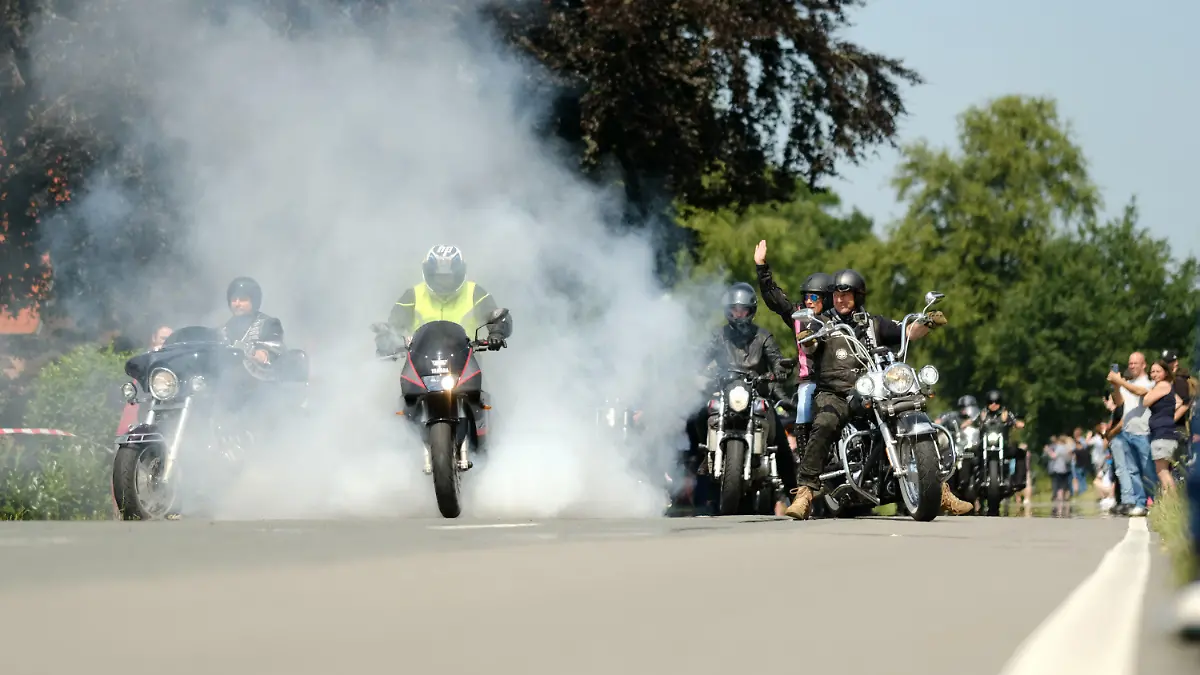 24.07.2021, Niedersachsen, Rhauderfehn: Motorradfahrer fahren am Haus des krebskranken Kilian vorbei. Tausende Biker sind den Aufrufen gefolgt, um dem Jungen noch einmal eine Freude zu bereiten. Mehrere Tausend Motorradfahrer und -fahrerinnen haben sich am Samstag im ostfriesischen Rhauderfehn getroffen, um einem krebskranken Jungen eine Freude zu machen. Das bestätigte die Polizei. Das Kind ist großer Motorradfan. Ein Aufruf in sozialen Netzwerken hatte große Resonanz gefunden, Biker aus ganz Deutschland wurden in dem Ort im Landkreis Leer erwartet. Foto: Markus Hibbeler/dpa +++ dpa-Bildfunk +++