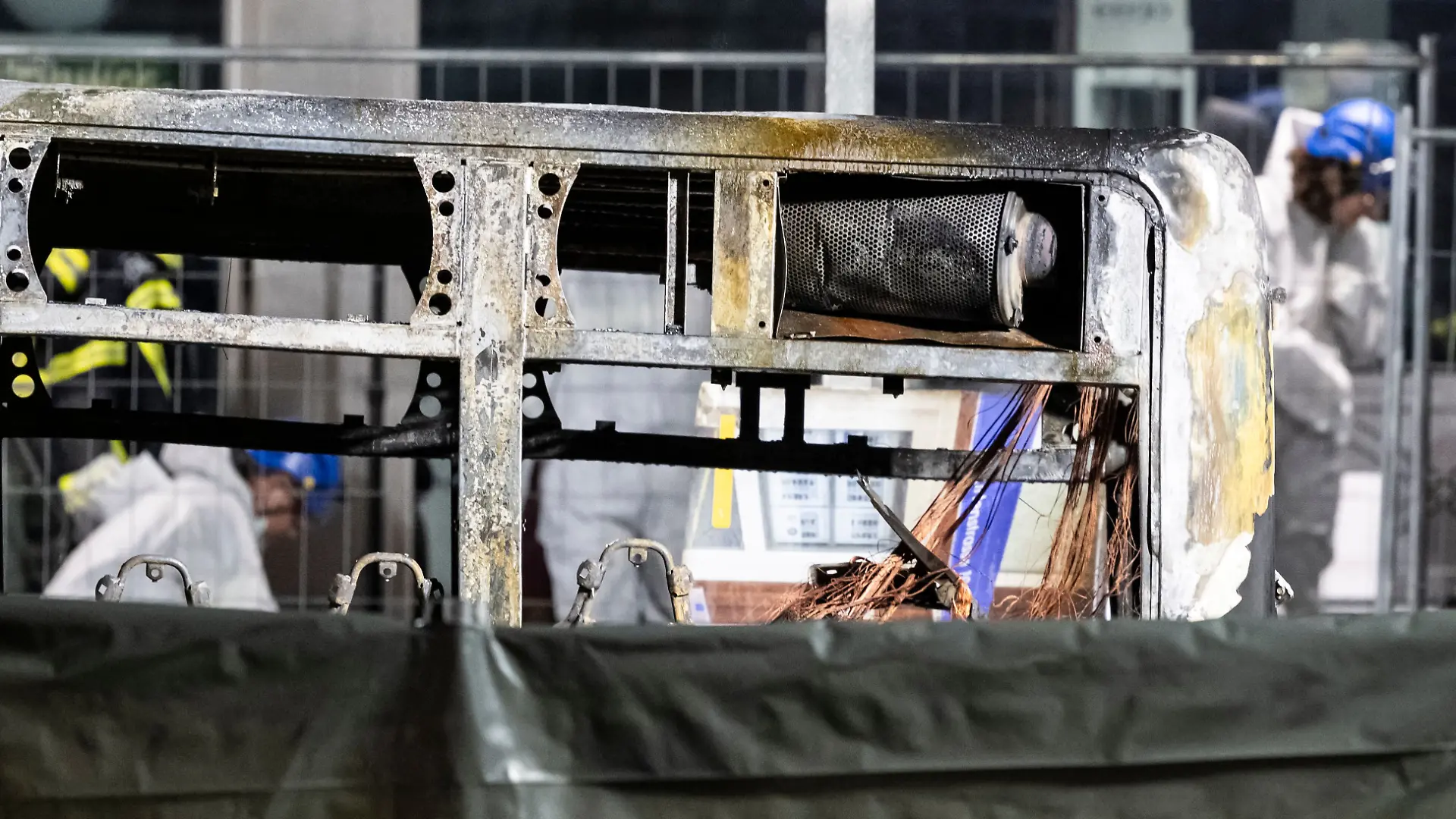 Brandermittler untersuchen die verkohlte Hülle eines Linienbusses, der in Brand geraten war. 
