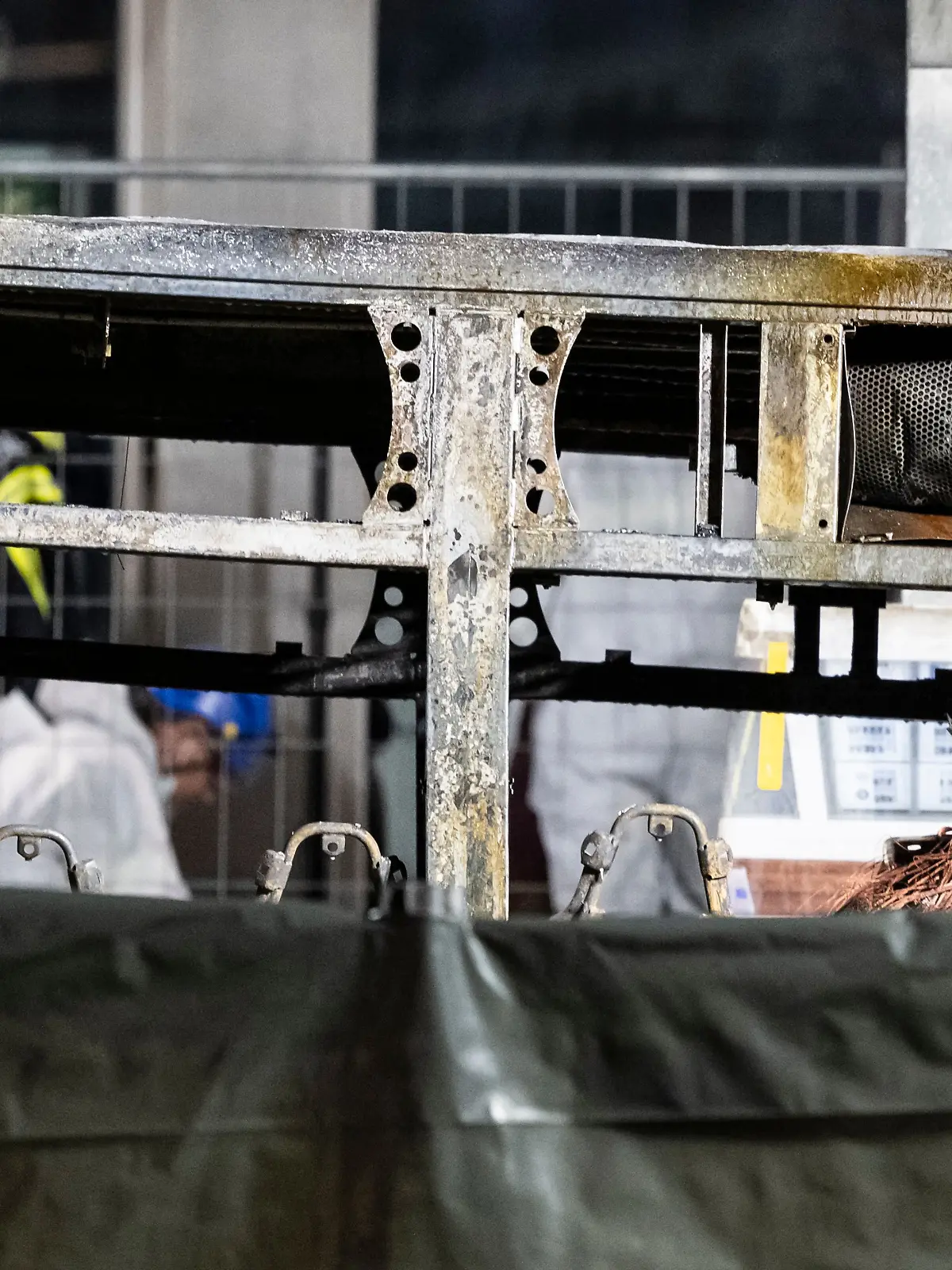 Brandermittler untersuchen die verkohlte Hülle eines Linienbusses, der in Brand geraten war. 