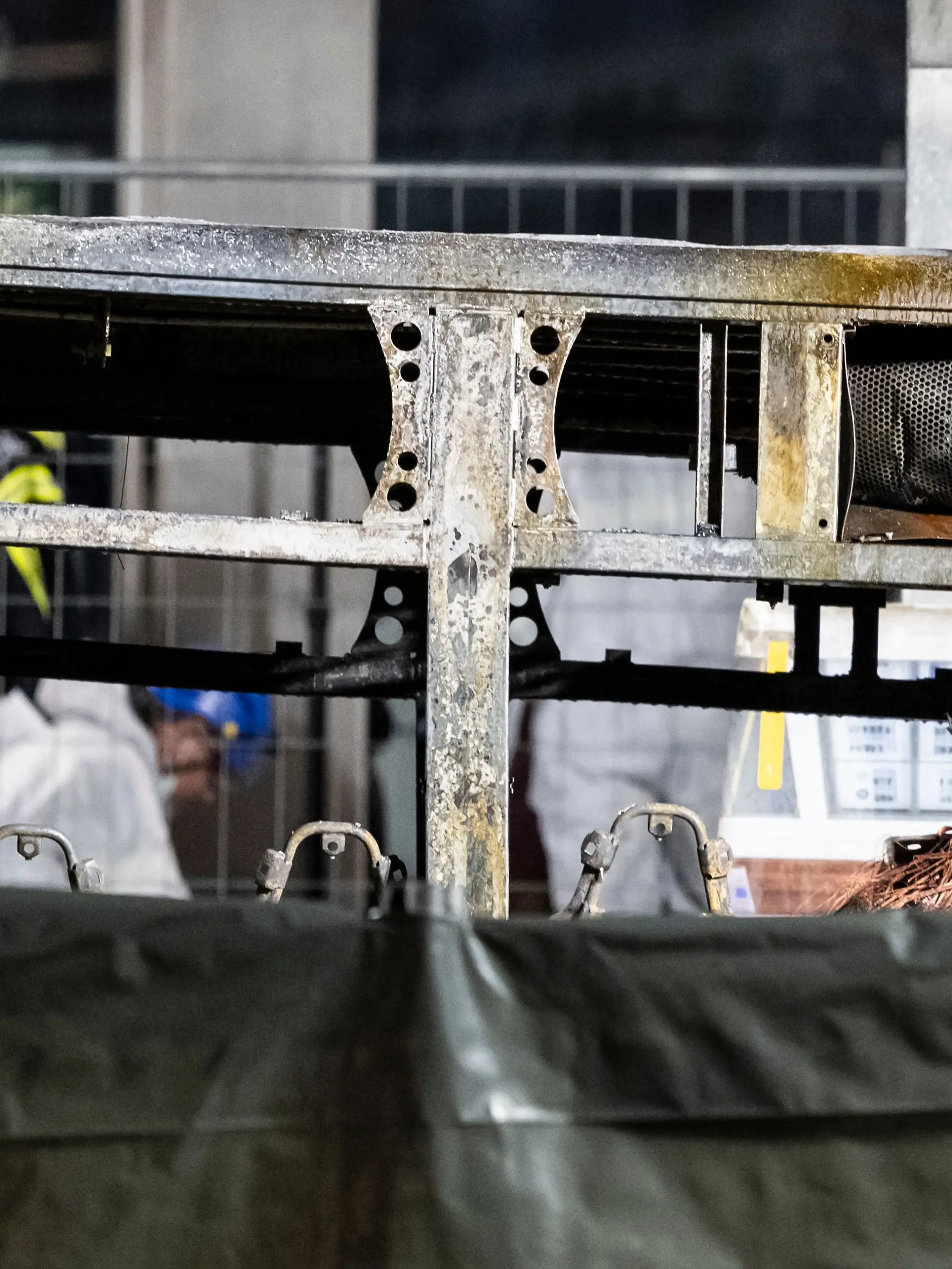 Brandermittler untersuchen die verkohlte Hülle eines Linienbusses, der in Brand geraten war. 