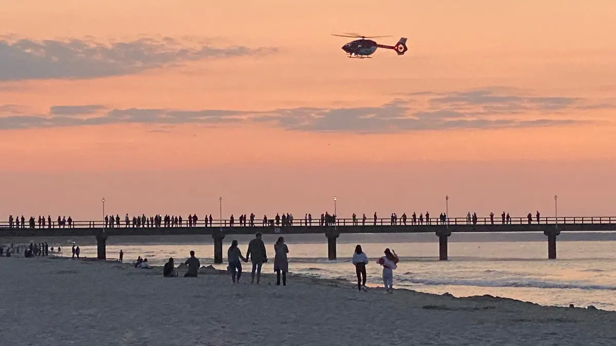 23.07.2021, Mecklenburg-Vorpommern, Zinnowitz: Ein Rettungshubschrauber fliegt über die Seebrücke im Ostseebad. Ein zwei Jahre alter Junge ist auf der Brücke auf Usedom bei einem Fotoversuch der Mutter ins Wasser gestürzt. (zu dpa «Zweijähriger fällt bei Foto der Mutter von Seebrücke») Foto: Tilo Wallrodt/dpa +++ dpa-Bildfunk +++
