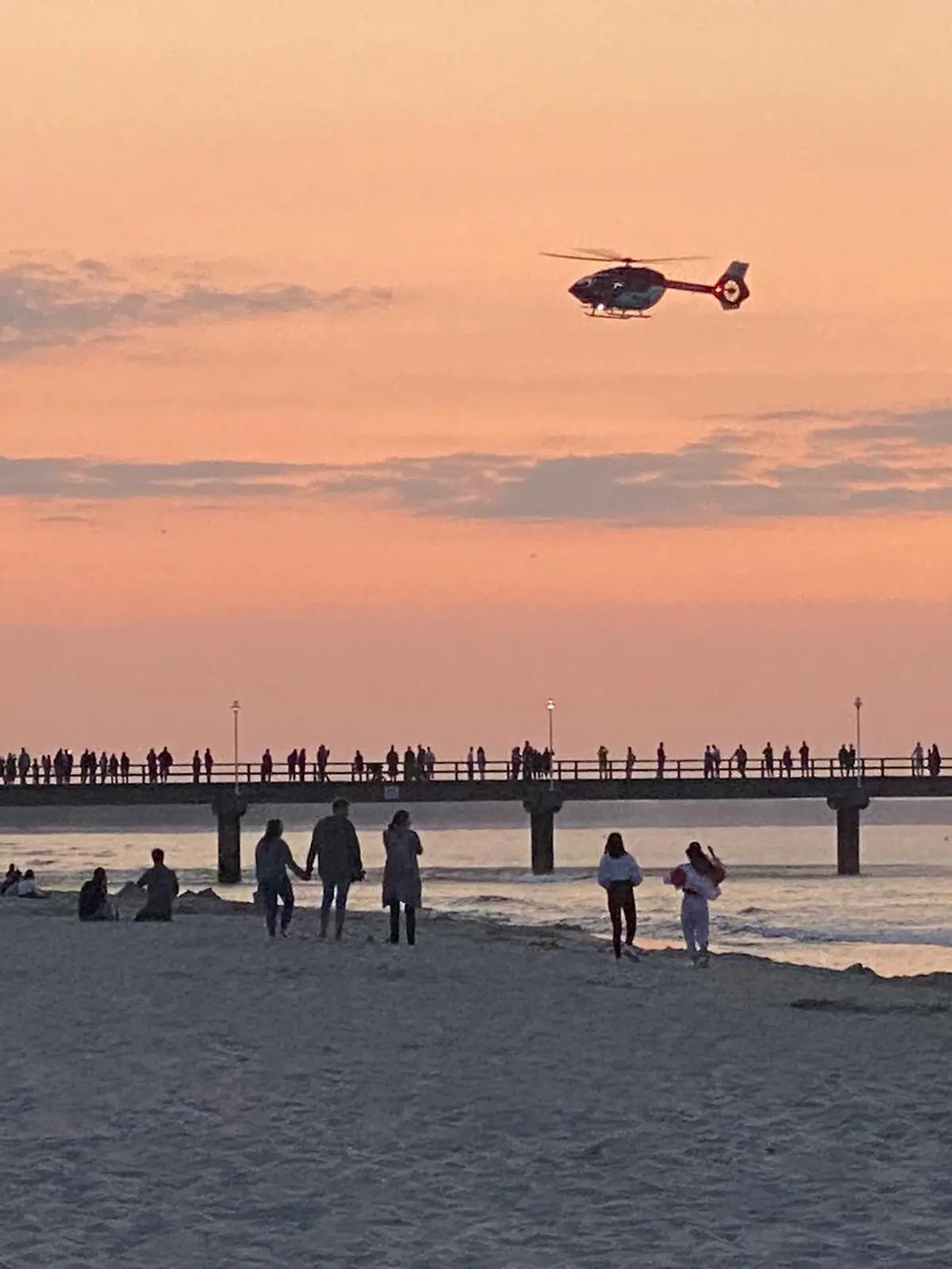 23.07.2021, Mecklenburg-Vorpommern, Zinnowitz: Ein Rettungshubschrauber fliegt über die Seebrücke im Ostseebad. Ein zwei Jahre alter Junge ist auf der Brücke auf Usedom bei einem Fotoversuch der Mutter ins Wasser gestürzt. (zu dpa «Zweijähriger fällt bei Foto der Mutter von Seebrücke») Foto: Tilo Wallrodt/dpa +++ dpa-Bildfunk +++