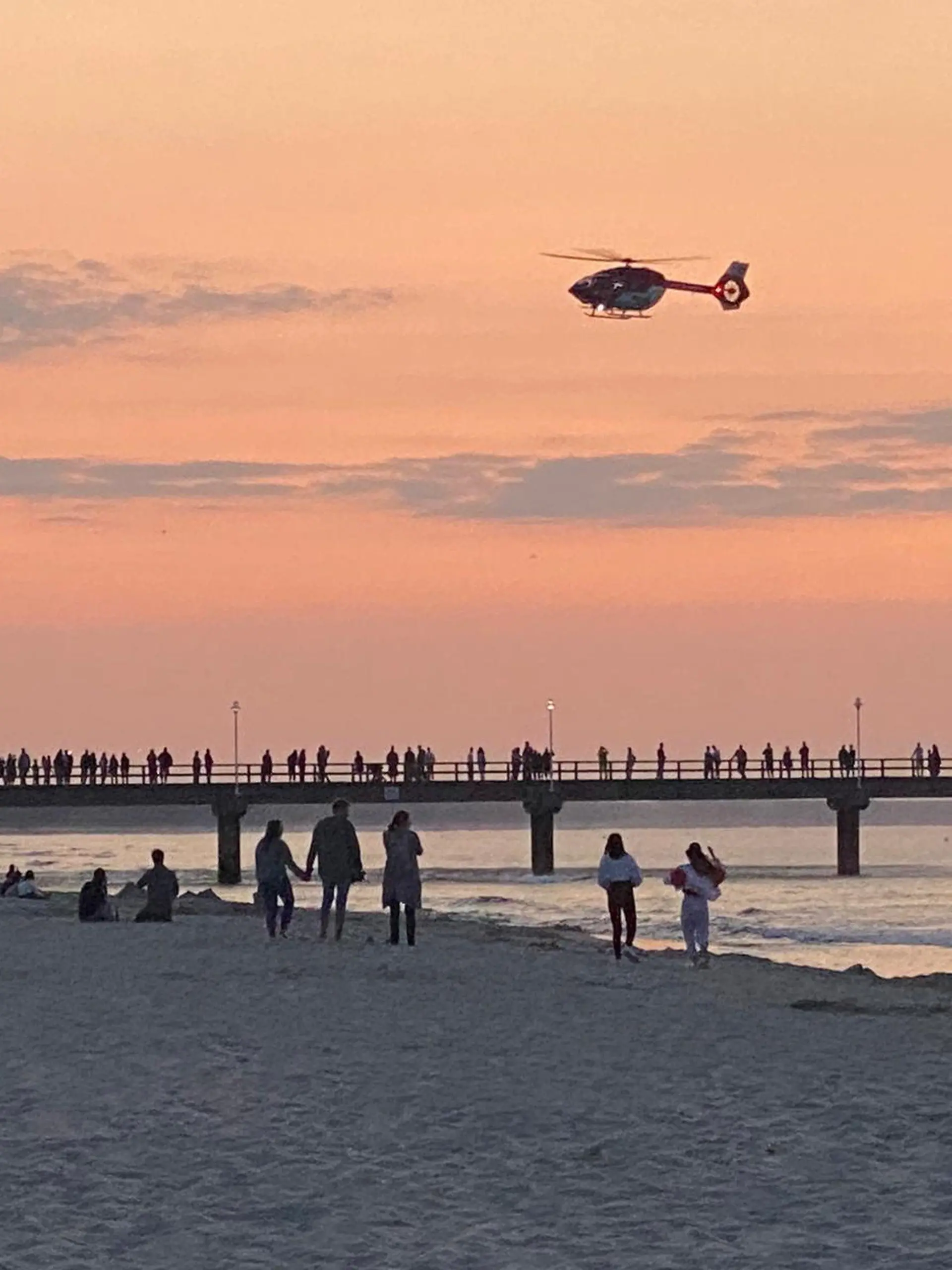 23.07.2021, Mecklenburg-Vorpommern, Zinnowitz: Ein Rettungshubschrauber fliegt über die Seebrücke im Ostseebad. Ein zwei Jahre alter Junge ist auf der Brücke auf Usedom bei einem Fotoversuch der Mutter ins Wasser gestürzt. (zu dpa «Zweijähriger fällt bei Foto der Mutter von Seebrücke») Foto: Tilo Wallrodt/dpa +++ dpa-Bildfunk +++