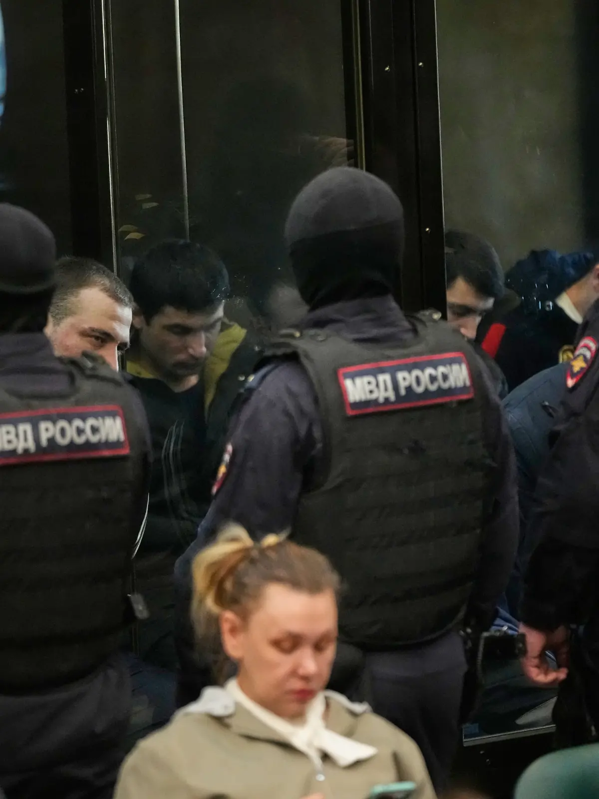 Men tried on the charges of involvement in a terror attack at the Crocus City Hall in March 2024 listen to the verdict in a glass cage at the Second Western District Military Court in Moscow, Russia, Thursday, March 12, 2026. (AP Photo/Pavel Bednyakov)