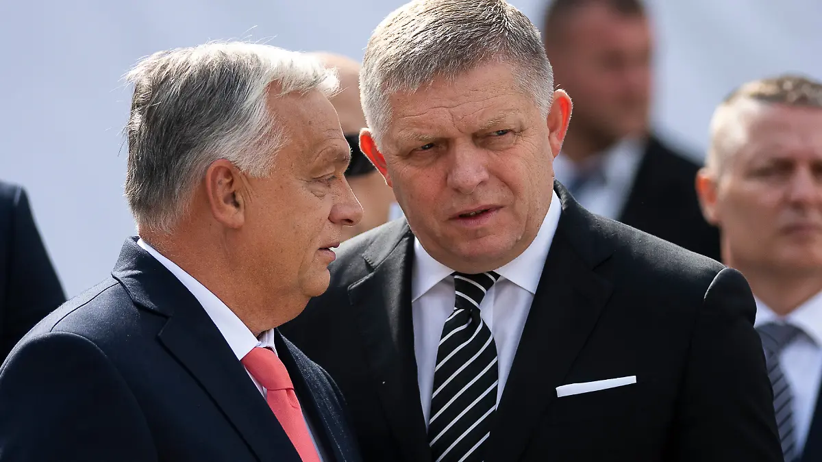 Hungary's Prime Minister Viktor Orban, left, and his Slovakian counterpart Robert Fico talk to each other before delivering their speeches during the 130th anniversary celebration of Mária Valeria Bridge in Esztergom, Hungary, on Sunday, Sept. 28, 2025. (AP Photo/Denes Erdos)