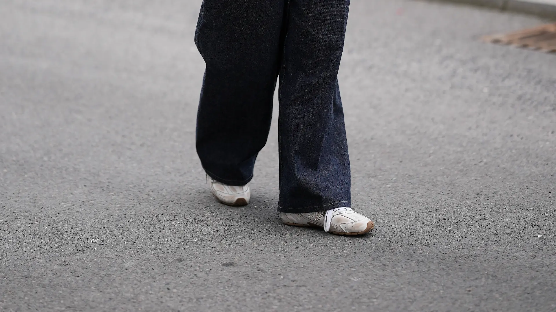 Frau mit beiger Jacke und dunkler Hose auf Straße